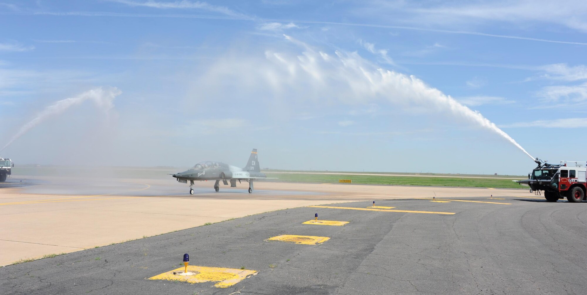 The fire department sprays water in a salute to Brig. Gen. Darryl Burke, 82nd Training Wing commander, after his T-38 "fini-flight" on Mar. 26, 2012 at Sheppard Air Force Base, Texas.  Fini-flights are a long-standing military aviator tradition honoring a pilot or commander on their departure from an assignment. (U.S. Air Force photo/Danny Webb)