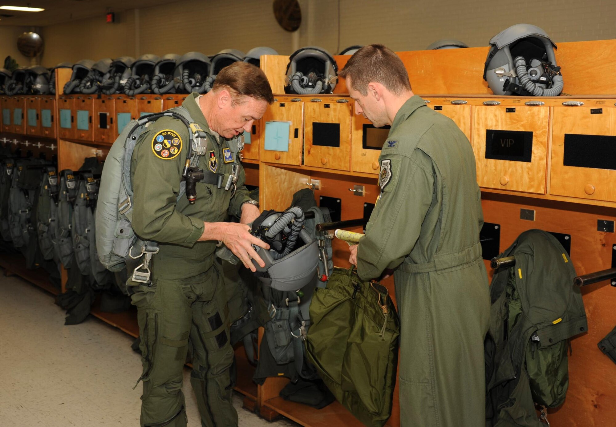 Brig. Gen. Darryl Burke, 82nd Training Wing commander, suits up as Col. Dieter Bariehs, 80th Flying Training Wing commander, looks on before his T-38 "fini-flight" at Sheppard Air Force Base, Texas on Mar. 26, 2012.  Fini-flights are a long-standing military aviator tradition honoring a pilot or commander on their departure from an assignment. (U.S. Air Force photo/Danny Webb)