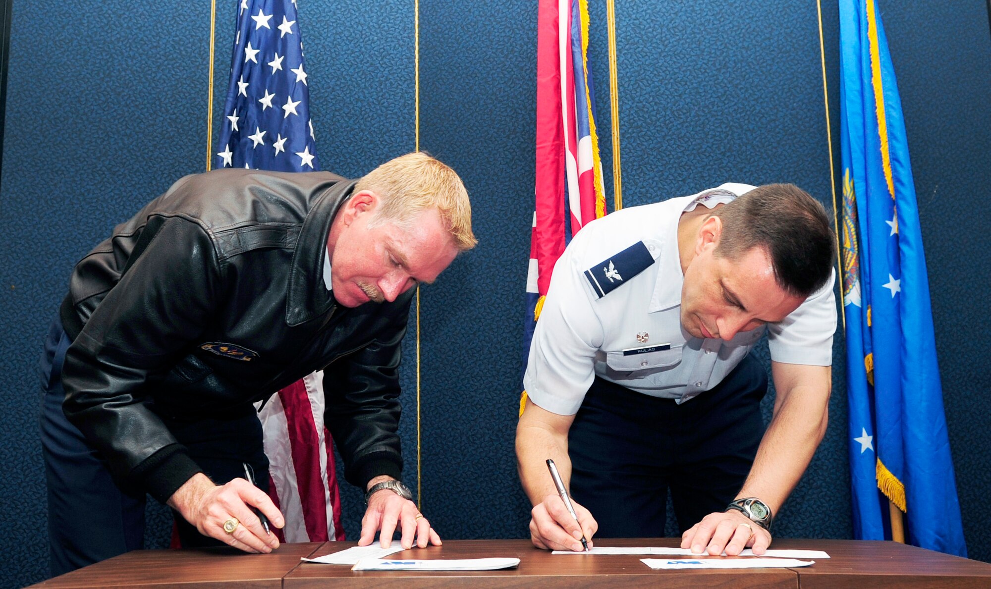 RAF MILDENHALL, England – Chief Master Sgt. Christopher Powell, (left) 100th Air Refueling Wing command chief, and Col. Christopher Kulas, 100th ARW commander, sign to donate to the Air Force Assistance Fund at the AFAF kick-off here March 26, 2012. The AFAF was established to provide an annual effort to raise funds for the charitable affiliates that provide support to Air Force families past, present and future. (U.S. Air Force photo/Senior Airman Ethan Morgan)