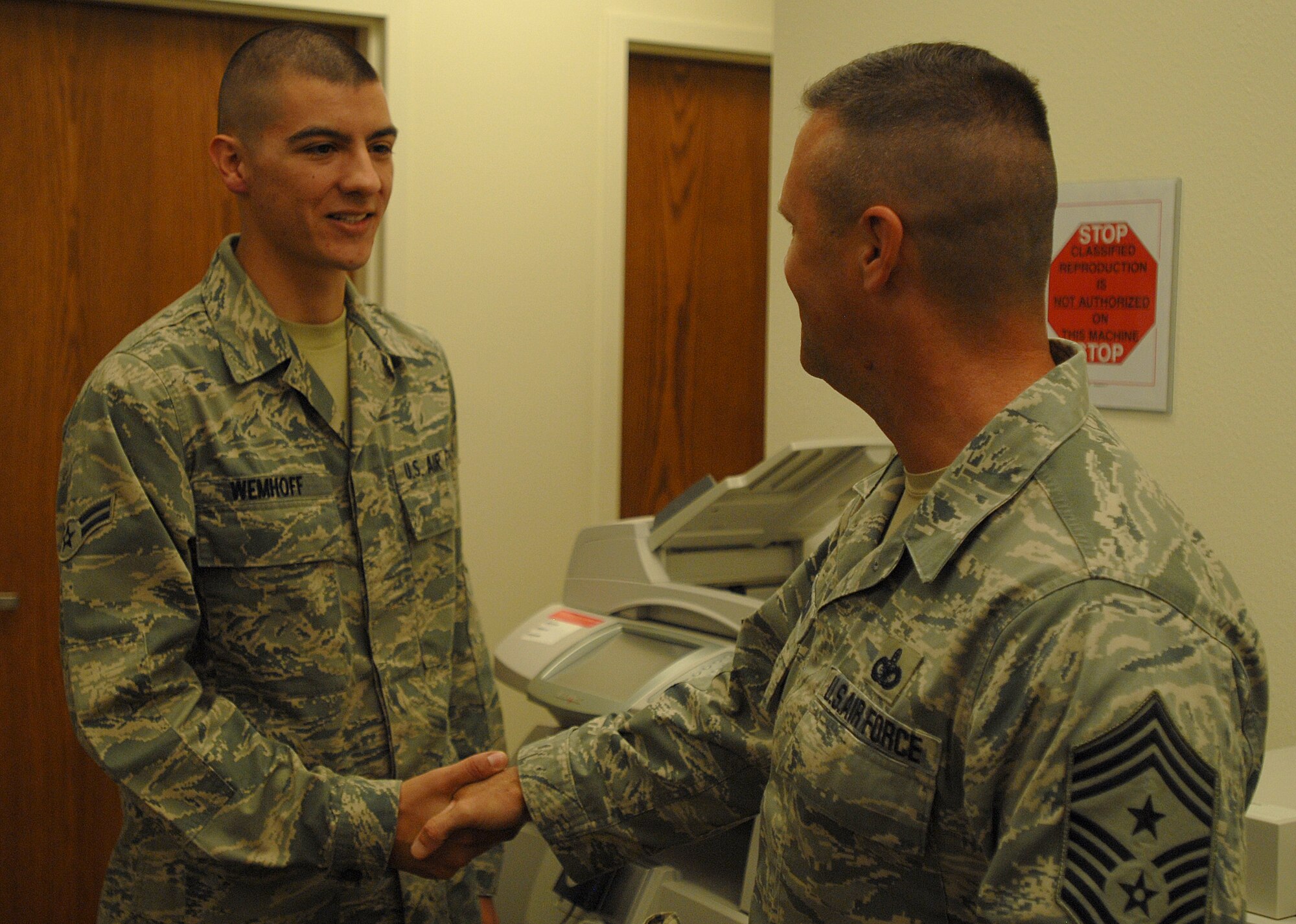 GOODFELLOW AIR FORCE BASE, Texas -- Chief Master Sgt. Oscar Mackin, 2nd Air Force Command Chief, coins Airman 1st Class Nathan Wemhoff, 17th Medical Operations Squadron, March 22. Wemhoff was recognized by his leadership as a dedicated and hardworking Airman. (U.S. Air Force photo/ Airman 1st Class Michael Smith)