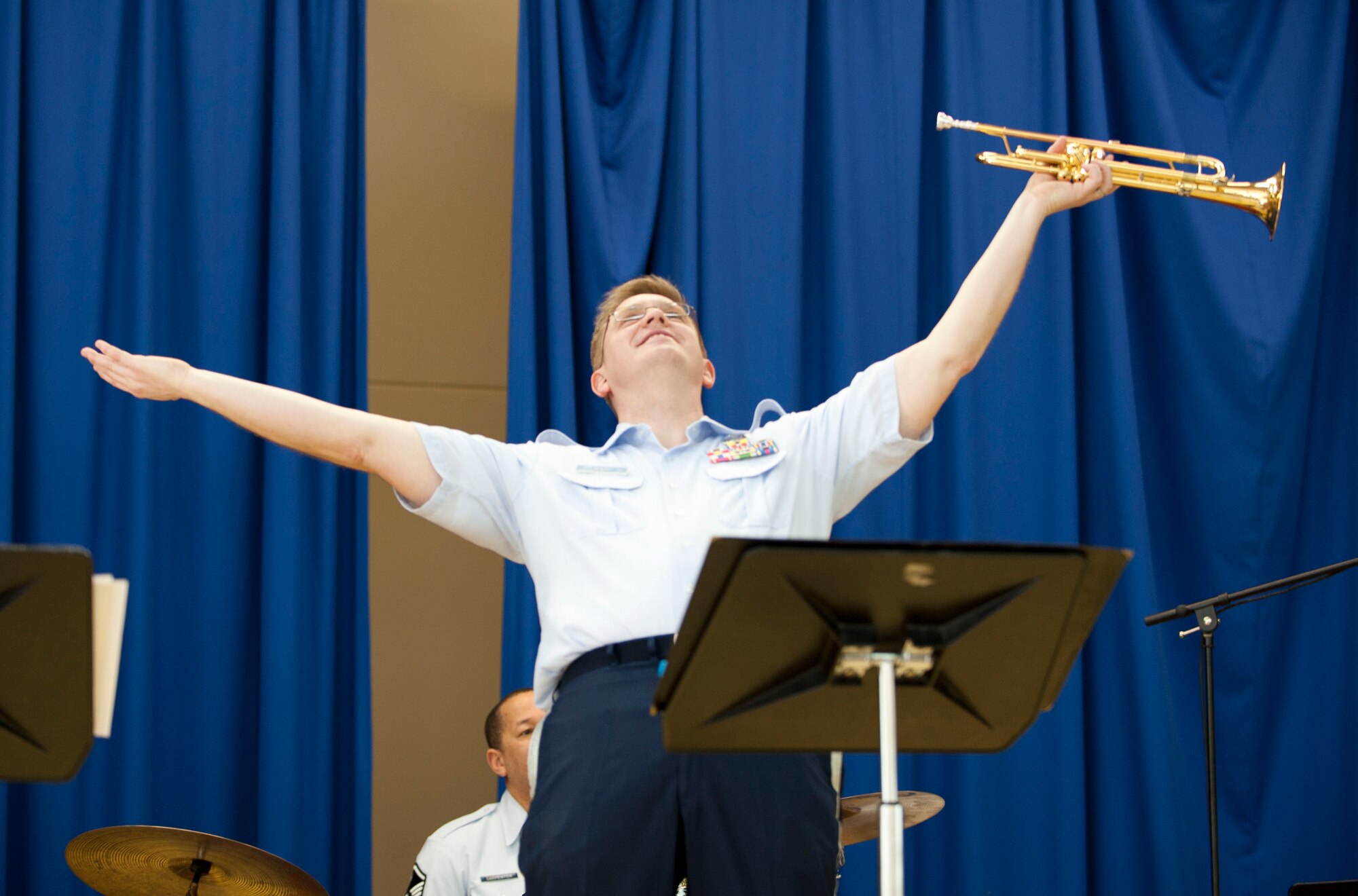 Tech. Sgt. Jeffrey Reich, trumpet player for U.S. Air Forces in Europe Band "Wings of Dixie," accepts applause in the Incirlik Unit School multipurpose room March 22, 2012, at Incirlik Air Base, Turkey. Wings of Dixie performed several times for the school as part of the Music in Our Schools program and put on a show for members of Team Incirlik in the Club Complex ballroom March 23. (U.S. Air Force photo by Senior Airman Clayton Lenhardt/Released)