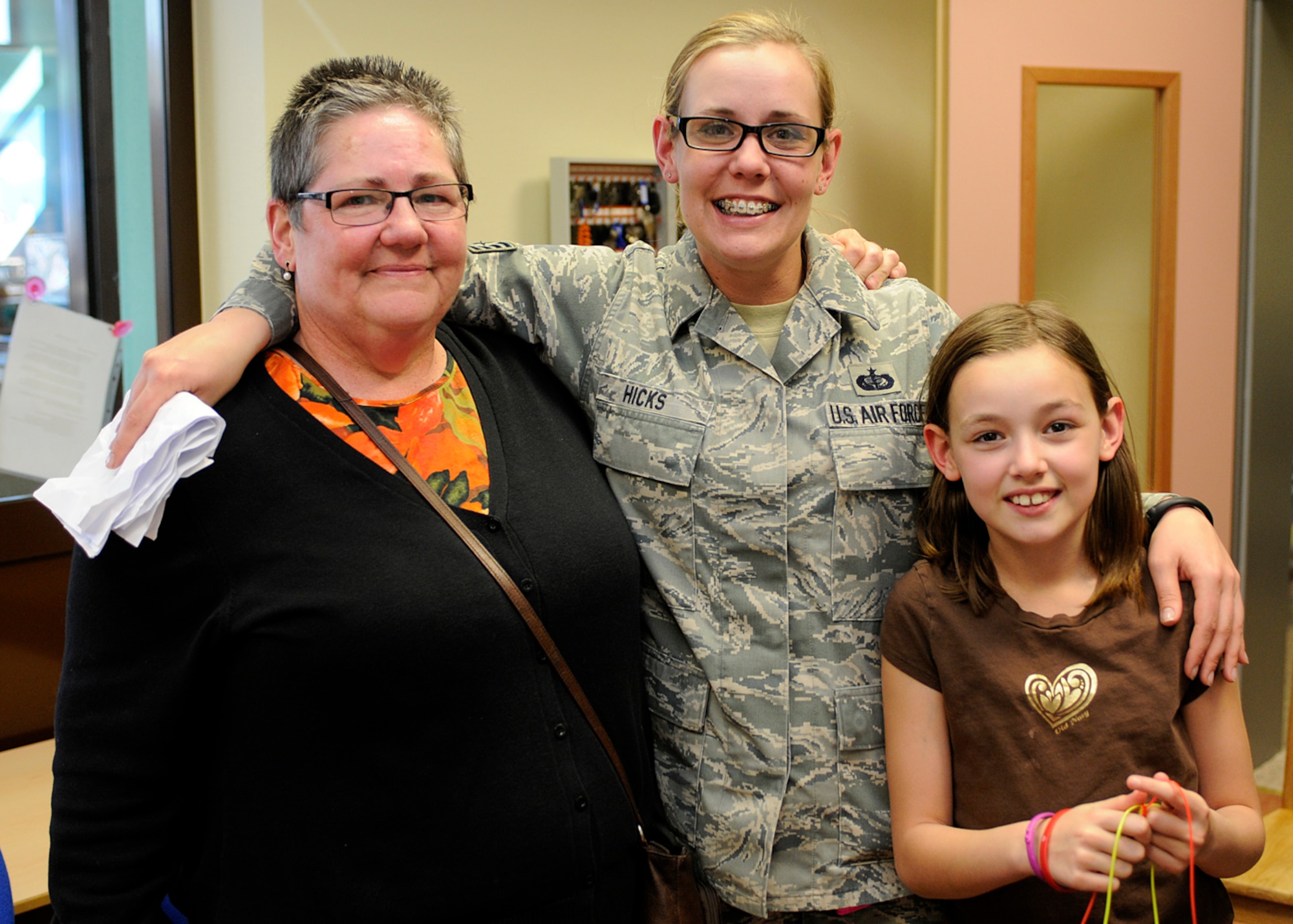 SPANGDAHLEM AIR BASE, Germany – Mother, Constance Besaw; daughter, Staff Sgt. Emma Hicks, 52nd Force Support Squadron; and granddaughter, Zoe Hicks, reunite March 26 at the Spangdahlem School Age Programs building after Hicks returned three weeks early from a deployment to southwest Asia. Besaw works with the base’s information, tickets and travel office and stayed with Zoe throughout Hicks’ deployment. Hicks convinced the Spangdahlem School Age Programs staff to hold a fake meeting between Besaw and Zoe to discuss cartoon drawings, and Hicks snuck into the room to reunite with her family. (U.S. Air Force photo by Staff Sgt. Daryl Knee/Released)