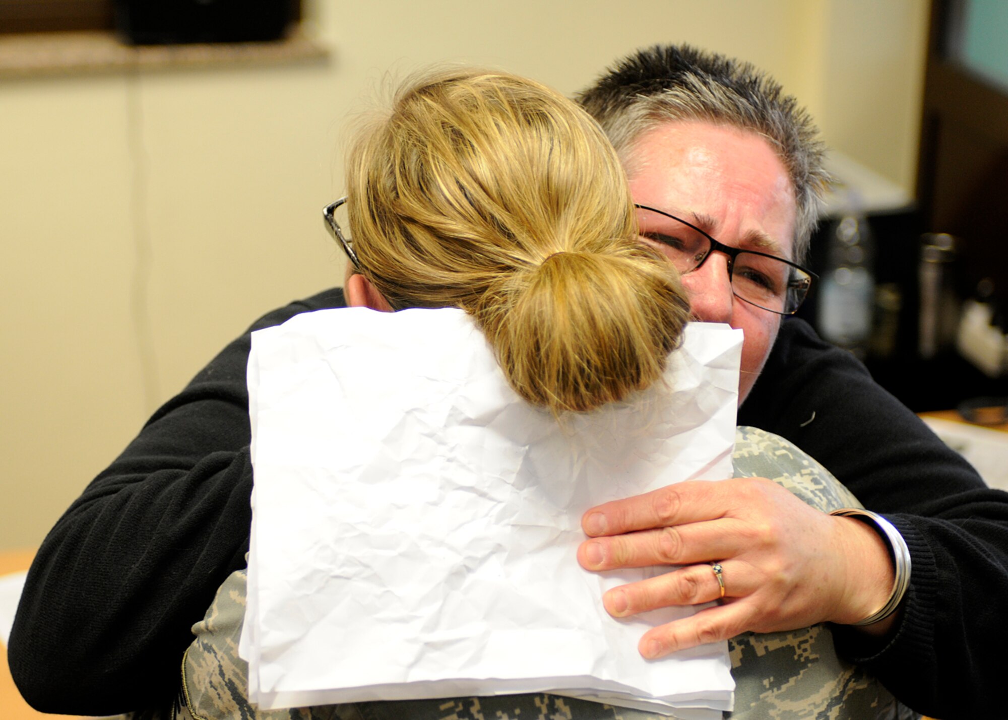 SPANGDAHLEM AIR BASE, Germany – Constance Besaw hugs her daughter, Staff Sgt. Emma Hicks, 52nd Force Support Squadron, after Hicks’ surprise return from a deployment to southwest Asia. Besaw works with the base’s information, tickets and travel office and stayed with Hick’s daughter, Zoe, throughout the deployment. Hicks convinced the Spangdahlem School Age Programs staff to hold a fake meeting between Besaw and Zoe to discuss cartoon drawings, and Hicks snuck into the room to reunite with her family. (U.S. Air Force photo by Staff Sgt. Daryl Knee/Released)