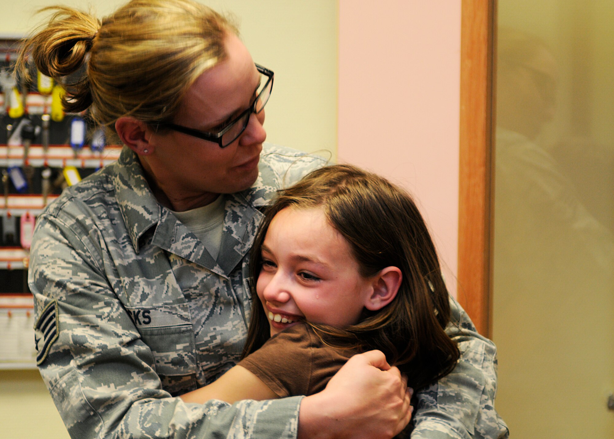 SPANGDAHLEM AIR BASE, Germany – Staff Sgt. Emma Hicks, 52nd Force Support Squadron, hugs her daughter, Zoe, at the Spangdahlem School Age Programs building here March 26. Hicks returned three weeks early from her deployment to southwest Asia and surprised her daughter and mother, Constance Besaw. Besaw works with the base’s information, tickets and travel office and stayed with Zoe throughout Hick’s deployment. (U.S. Air Force photo by Staff Sgt. Daryl Knee/Released)