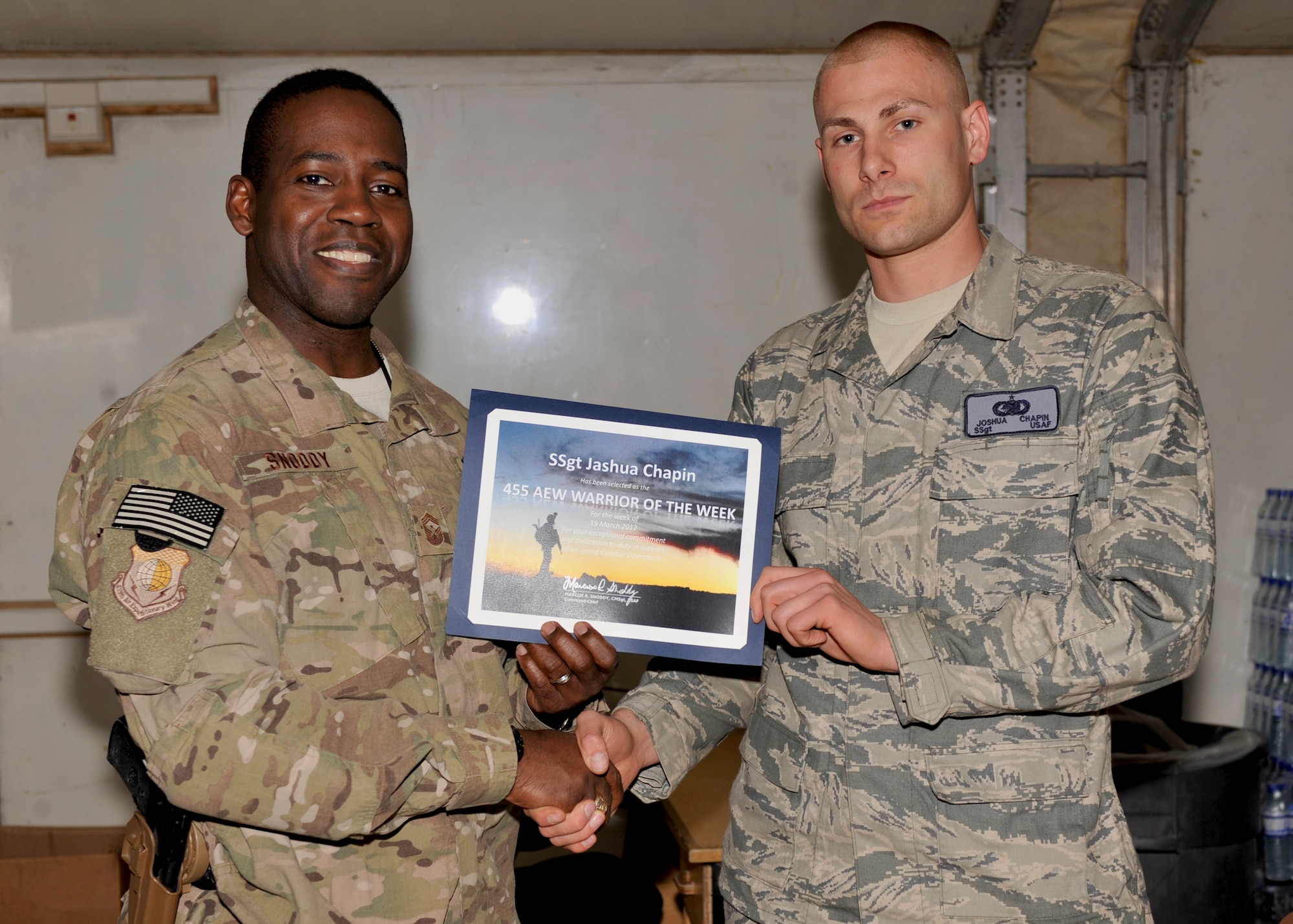 BAGRAM AIRFIELD, Afghanistan— Staff Sgt. Joshua Chapin receives the Warrior of the Week award from 455th Air Expeditionary Wing Command Chief Chief Master Sgt. Marcus Snoddy at Bagram Airfield, Afghanistan, March 27, 2012. Chapin is a fuels laboratory supervisor with the 455th Expeditionary Logistics Readiness Squadron and earned the Warrior of the Week award for his hard work and dedication to excellence. (U.S. Air Force photo/Airman 1st Class Ericka Engblom)