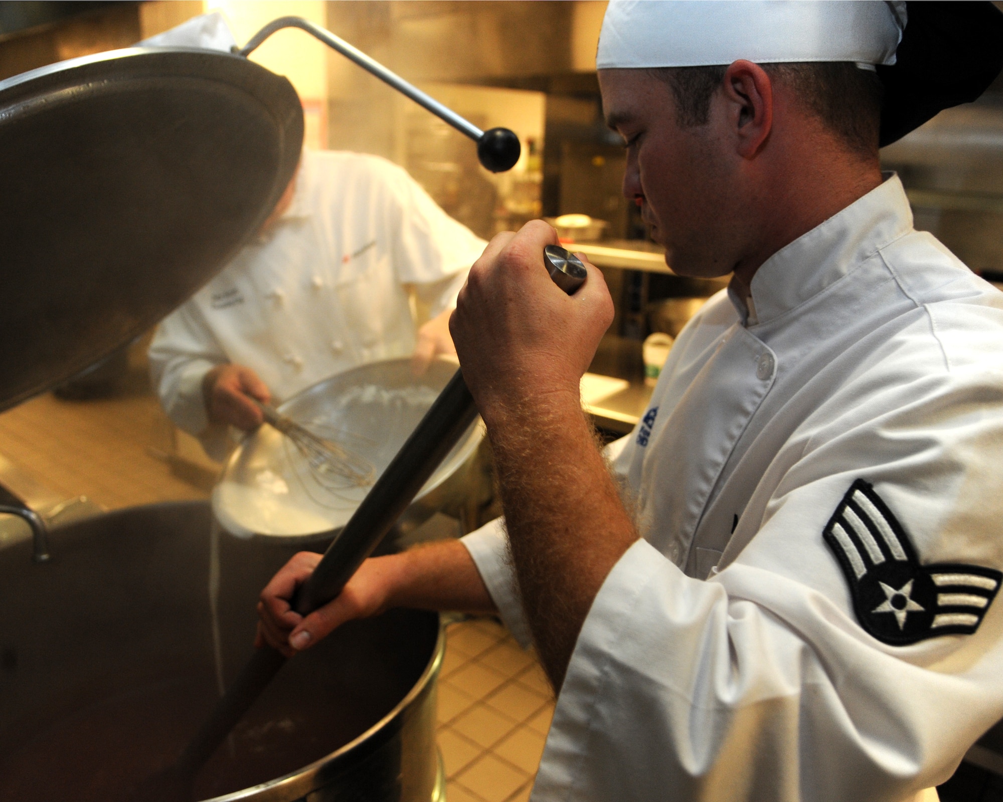 Senior Airman Brady McDede, 6th Force Support Squadron food service technician, stirs a large pot of Manhattan clam chowder, at the Citi Bank corporate building in Tampa, Fla., March 23, 2012. McDede has been training with civilian chefs to help improve the dining conditions on MacDill Air Force Base, Fla. (U.S. Air Force photo by Airman Basic David Tracy)