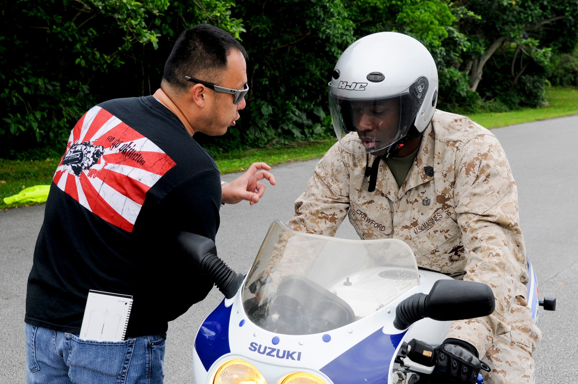 U.S. Air Force Tech. Sgt. Andy Chang, guest motorcycle safety course instructor from the 390th Intelligence Squadron, gives advice on downshifting to student U.S. Marine Corps Gunnery Sgt. Judah Crawford, from Combat Logistics Regiment 3 on Camp Foster, during a motorcycle safety course on Kadena Air Base, Japan, March 20, 2012. Motorcycle safety courses are scheduled up to once a week, depending on the number of students signing up. (U. S. Air Force photo by Airman 1st Class Tara A. Williamson/Released)