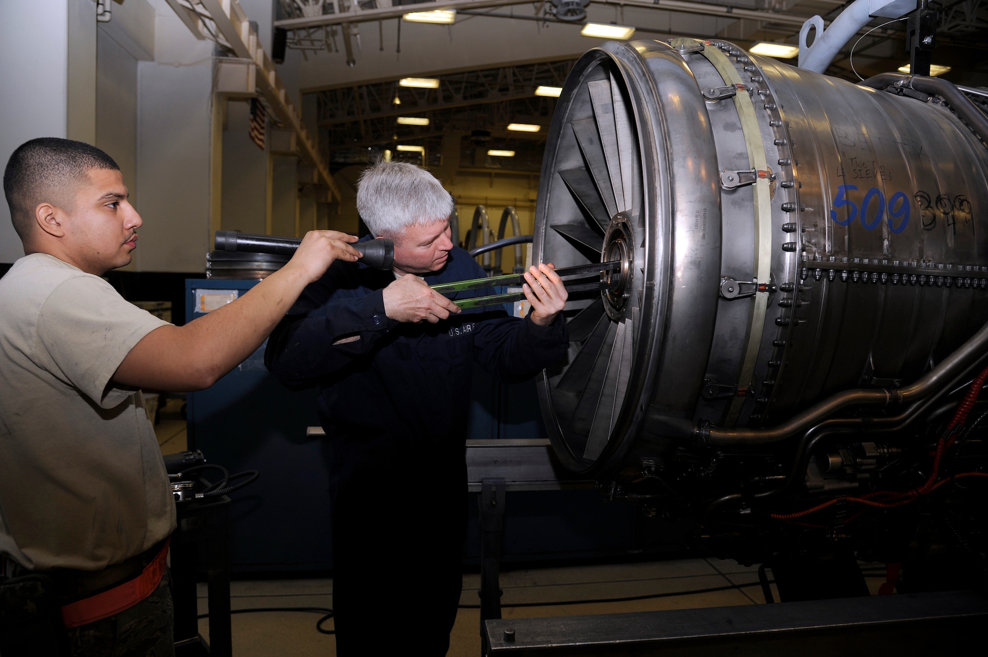 U.S. Air Force Senior Airman Rubiani Navarrette, 35th Maintenance Squadron aerospace propulsion journeyman, assists Col. Al Wimmer, 35th Fighter Wing vice commander, with breaking down an F-16 Fighting Falcon F110-100 model engine at Misawa Air Base, Japan, March 27, 2012. The engine was being broken down for upgrades which are part of the service life extension program. (U.S. Air Force photo by Tech. Sgt. Marie Brown/Released)
