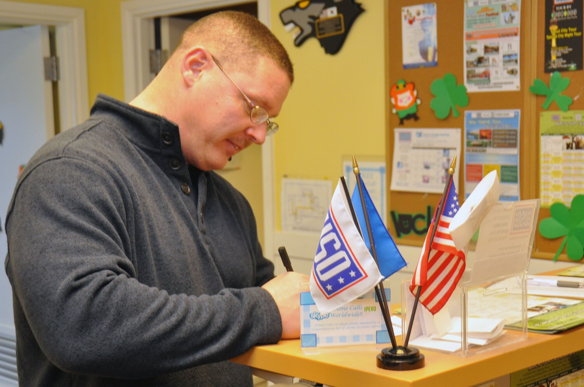 Senior Master Sgt. Stuart Camp, 51st Fighter Wing Public Affairs Office, signs the guest log during the bi-weekly Dine for a Dime program at the Osan USO March 14, 2012. The Dine for a Dime program offers service members and their families a home cooked meal every second and fourth Wednesday of each month. (U.S. Air Force photo/Airman 1st Class Michael Battles)