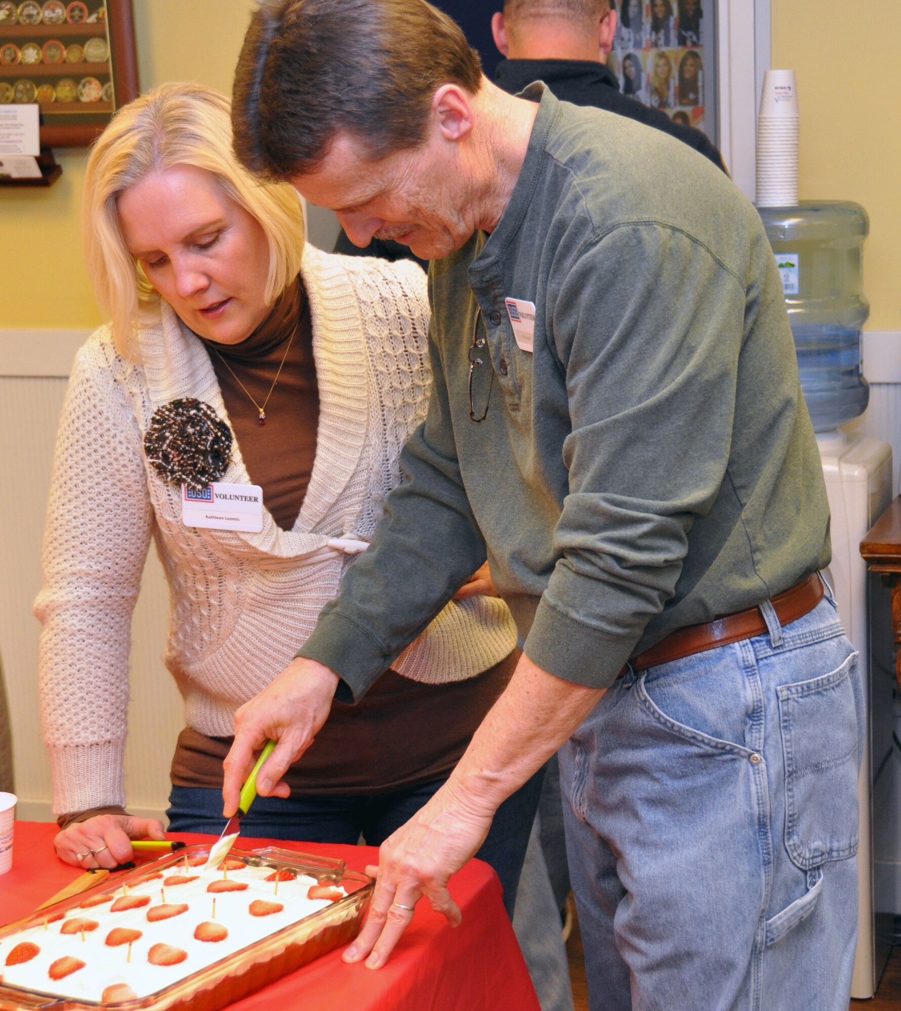 Russ and Kathy Loomis, both pastors of a church in the local community, help serve dessert to service members during the bi-weekly Dine for a Dime program at the Osan USO March 14, 2012. The Dine for a Dime program offers service members and their families a home cooked meal every second and fourth Wednesday of each month. (U.S. Air Force photo/Airman 1st Class Michael Battles)