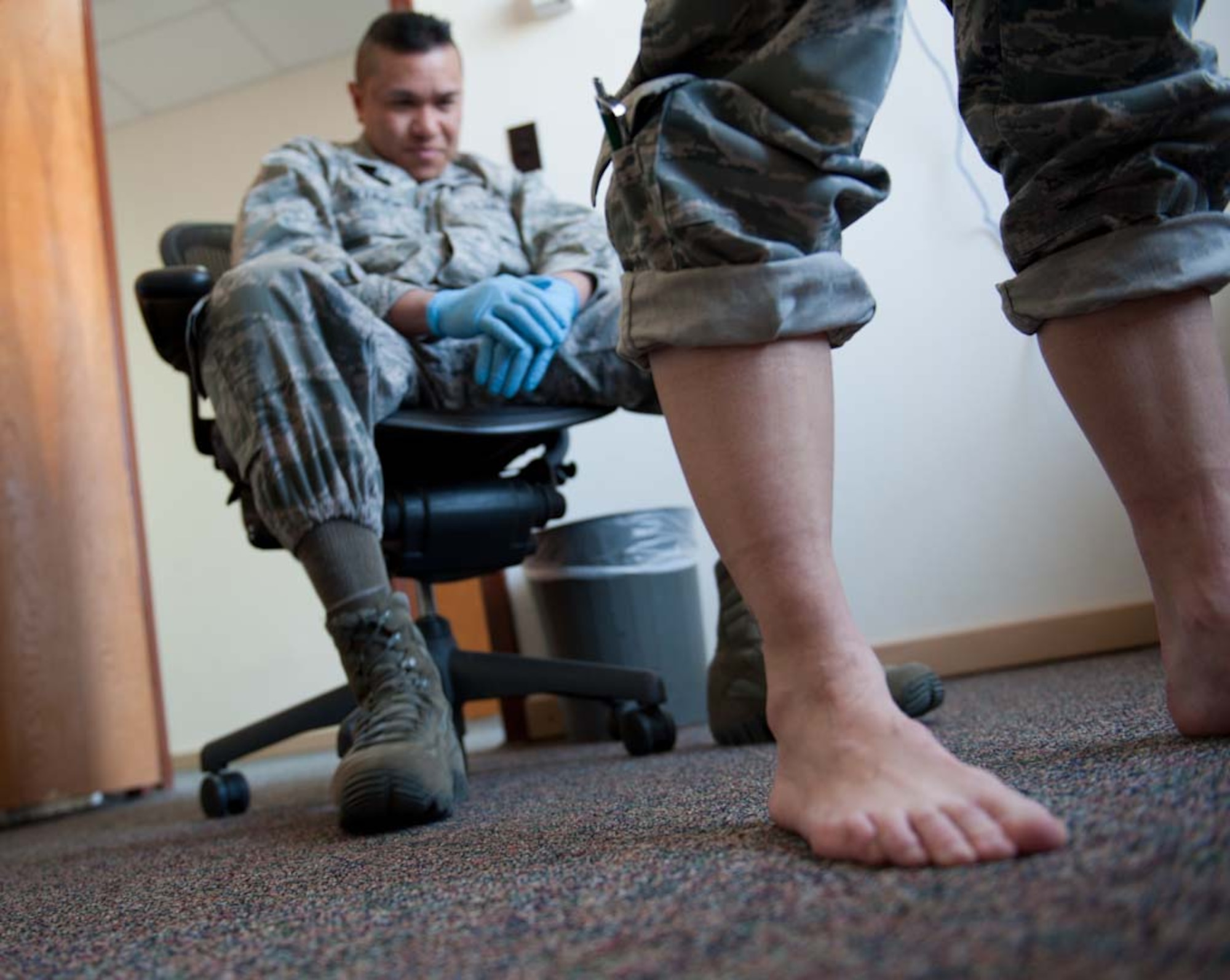 Capt. Richard Villanueva, 39th Medical Group physical therapist, inspects the hip mobility of a patient during a running shoe assessment at the Health Expo March 23, 2012, at Incirlik Air base, Turkey. The Health Expo allowed the Health and Wellness Center staff to showcase their various programs and services. (U.S. Air Force photo by Senior Airman Jarvie Z. Wallace/Released)