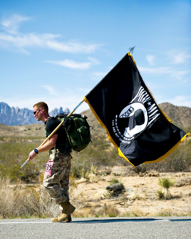 A participant in the 23rd Annual Bataan Memorial Death March carries a prisoners of war and missing in action flag along the course on White Sands Missile Range, N.M., March 25, 2012, to honor the more than 76,000 POW/MIAs that were taken at Bataan and Corregidor during World War II.