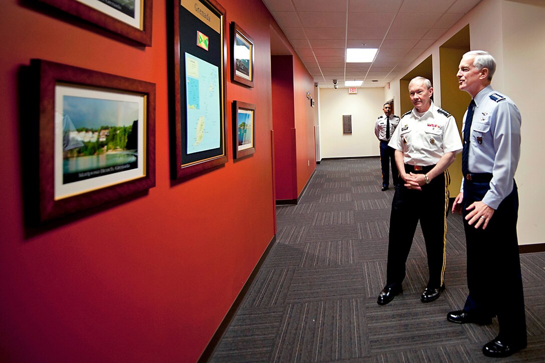 Army Gen Martin E. Dempsey, chairman of the Joint Chiefs of Staff, and Air Force Gen. Douglas M. Fraser, commander of U.S. Southern Command, chat before touring Southcom's headquarters in Miami, March 26, 2012.