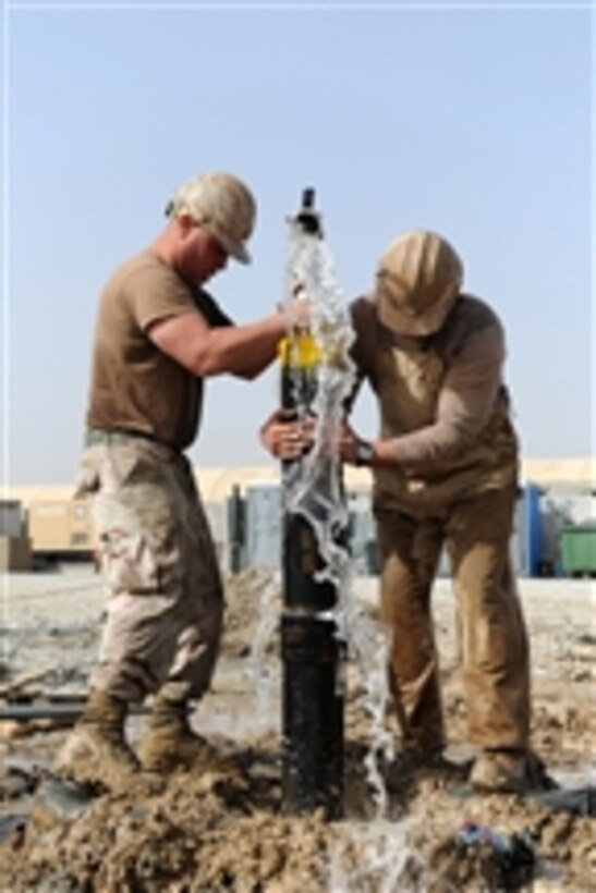 Petty Officer Jon M. Wawrek and Petty Officer 2nd Class Michael A. Castaldi, both assigned to Naval Mobile Construction Battalion 11, cap an artesian water well in the Panjwai District of Zangabad, Afghanistan, on March 17, 2012.  Naval Mobile Construction Battalion 11 is home ported in Gulfport, Miss., and deployed to Afghanistan to conduct general, mobility, survivability engineering operations and defensive operations.  