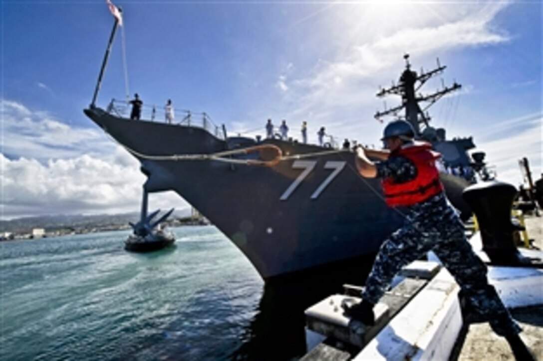 U.S. Navy Petty Officer 2nd Class Joshua Thomas casts a mooring line to sailors aboard the guided-missile destroyer USS O'Kane as it departs Joint Base Pearl Harbor-Hickam, Hawaii, March 23, 2012. O'Kane is deploying under the Middle Pacific Surface Combatant deployment concept, in which Pearl Harbor-based ships deploy in support of operations primarily in the western Pacific region.