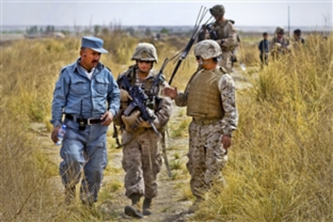 A patrol leader with a team of Afghan police speaks with U.S. Marine Staff Sgt. Alejandro Santiago through translators during a patrol in the Khan Neshin district, Afghanistan, March 24, 2012. Santiago is an assistant team leader assigned to the Police Advisor Team, Delta Company, 1st Light Armored Reconnaissance Battalion.