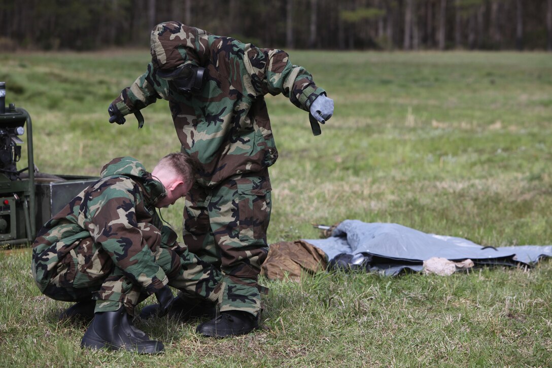 Cpl. Benjamin T. Streeter (left), a chemical, biological, radiological and nuclear warfare specialist with Combat Logistics Regiment 27, 2nd Marine Logistics Group, assists another Marine in securing his Mission-Oriented Protective Posture gear during a hands-on readiness exercise aboard Camp Lejeune, N.C., March 28, 2012.  Streeter, along with other CBRN specialists, hosted a practical application class for Marines of Landing Support Company, CLR-27, 2nd MLG so they could learn about different types of CBRN attacks and how to react to them.