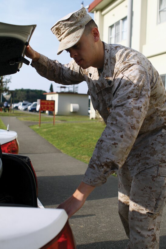 Cpl. Tristan I. Hobson checks the trunk of a patrol car for supplies on Camp Foster March 28. Hobson saved a local community member’s life on Camp Kinser Feb. 18 with the aid of an automated external defibrillator. Hobson is a military policeman with Headquarters and Service Battalion, Marine Corps Base Camp Butler.