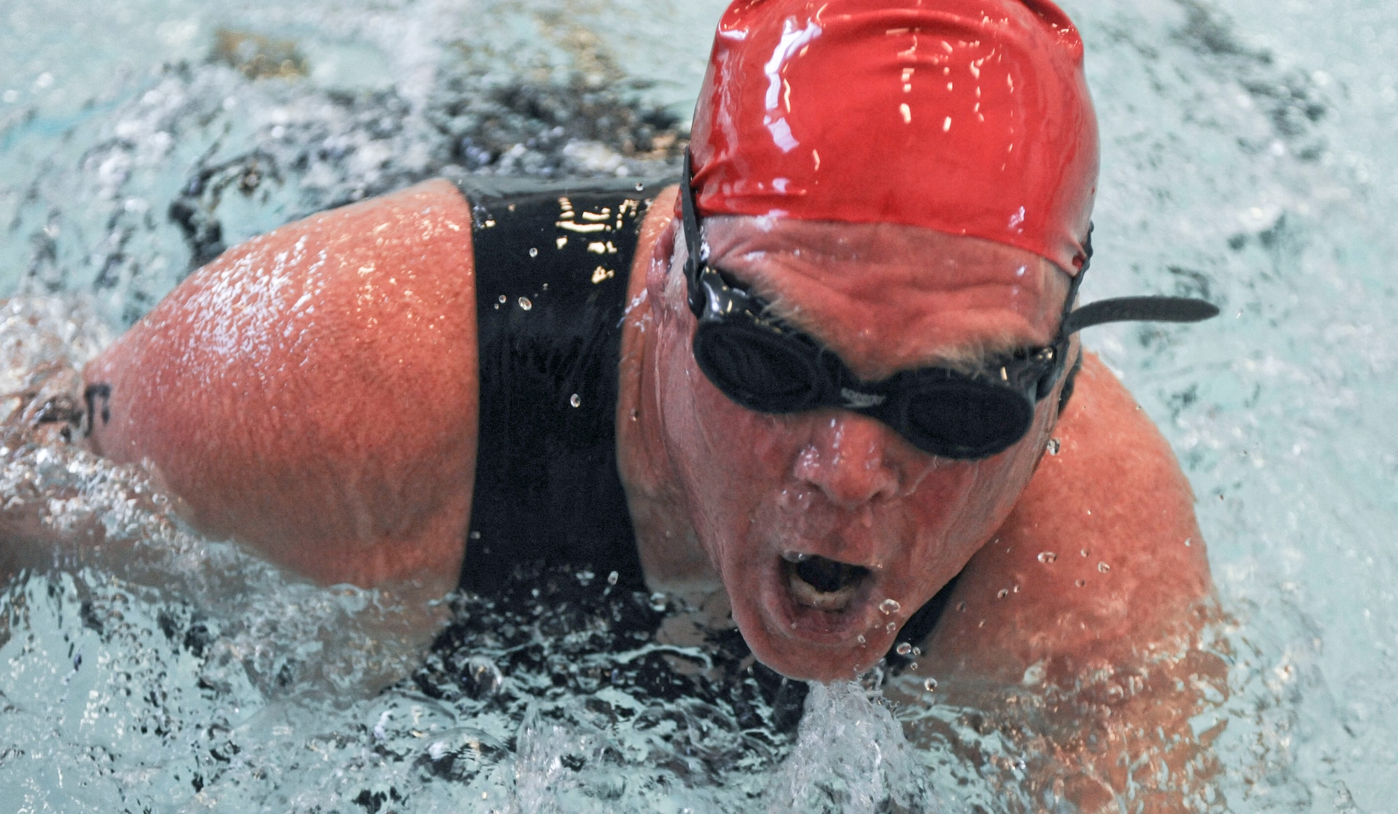 Dave Carpenter breaks through water for air during the Bellamy Fitness Center’s Indoor Triathlon at Ellsworth Air Force, S.D., March 24, 2012.  The triathlon began with competitors swimming 300 yards in the indoor pool. (U.S. Air Force photo by Airman 1st Class Anania Tekurio/Released) 

