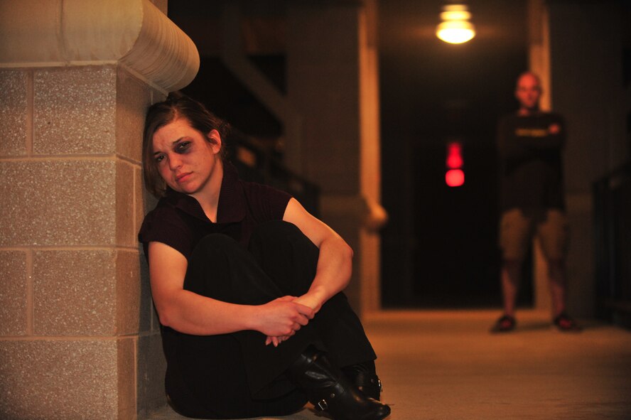 U.S. Air Force Airman Jodi Lange, 20th Medical Support Squadron, simulates a sexually abused woman watched over by her abuser, closed in with nowhere to go as a result of sexual assault, Shaw Air Force Base, S.C. March 25, 2012. Studies show men, women and children of all ages, races, religions, and economic classes can be and have been victims of sexual assault. (U.S. Air Force photo by Airman 1st Class Ashley L. Gardner/ Released)