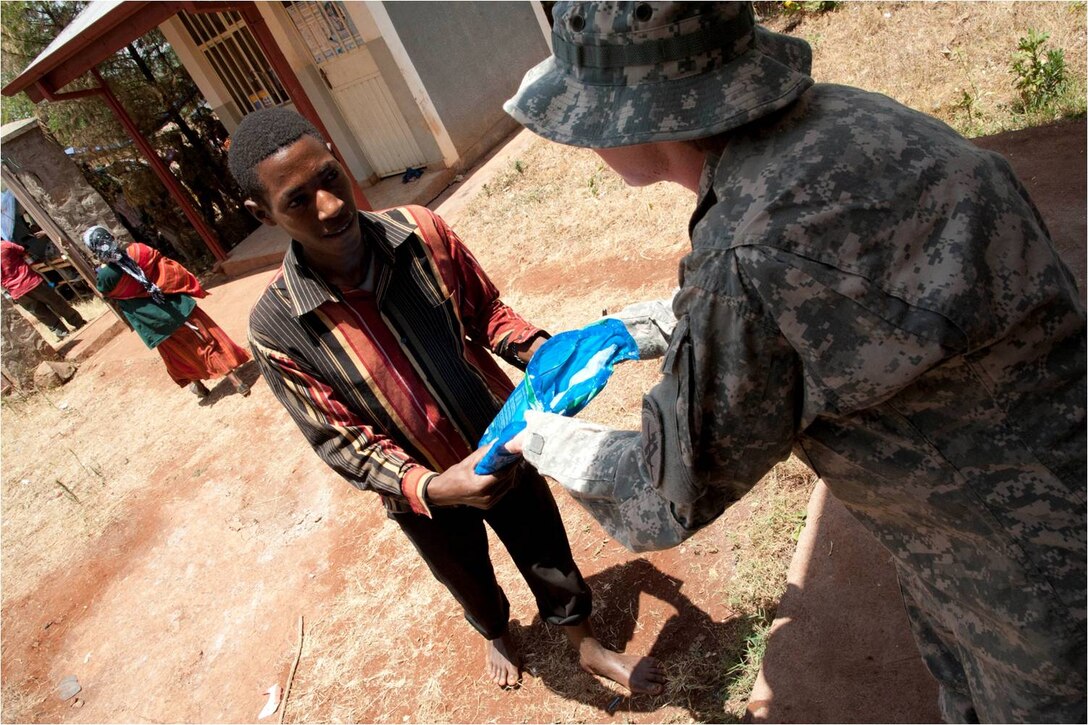 DEBAKA DEBOBESA, Ethiopia (Mar. 15, 2012) - U.S. Army Staff Sergeant Melissa McGaughey, Civil Affairs Team 4905 team sergeant and native of Fort Woth, Texas hands an insecticide-treated net to an Ethiopian man in Debaka Debobesa, Ethiopia, March 15. As part of an effort to impede an expected spike of malaria in the region,CAT 4905 delivered 18,000 packs of insecticide-treated bed nets, rope and nails to Ethiopians in Samaro and Debaka Debobesa, March 15 and 16. (U.S. Air Force photo by Staff Sergeant Andrew Caya)