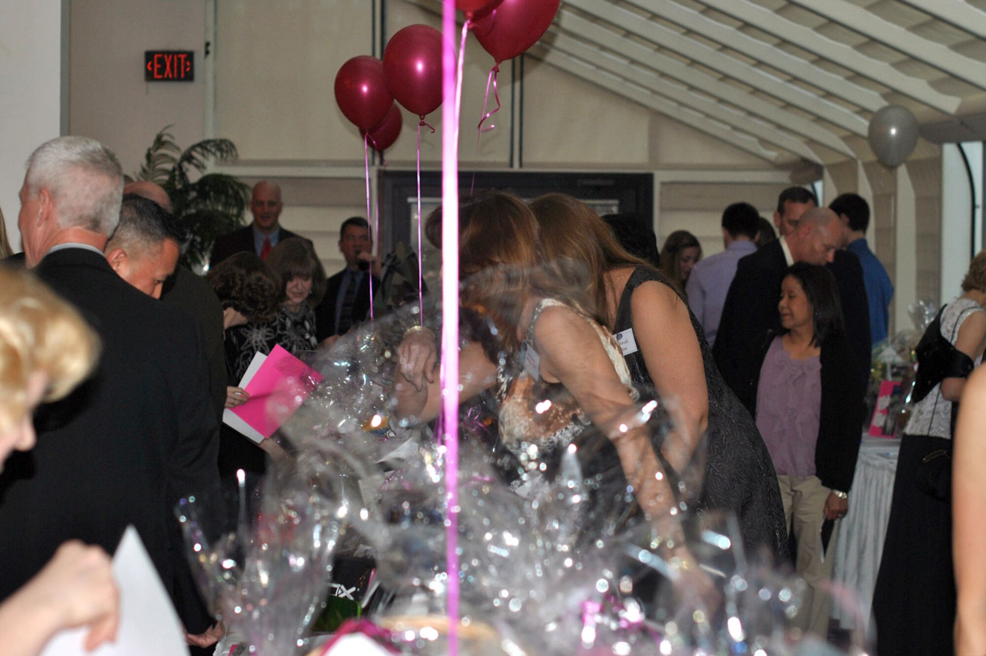 HANSCOM AIR FORCE BASE, Mass. – Attendees crowd around to get a closer look during the silent auction portion of the Hanscom Spouses Club’s “Razzle Dazzle” scholarship auction March 24 at the Minuteman Commons. More than $13,000 was raised to go toward scholarships for Hanscom area military dependents. (Courtesy photo)