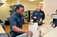 Marcus White washes dishes while Jason Glefke prepares something to eat during the night shift at one of the base fire stations. They are both Robins Fire Department lieutenants. (U. S. Air Force photo by Sue Sapp)