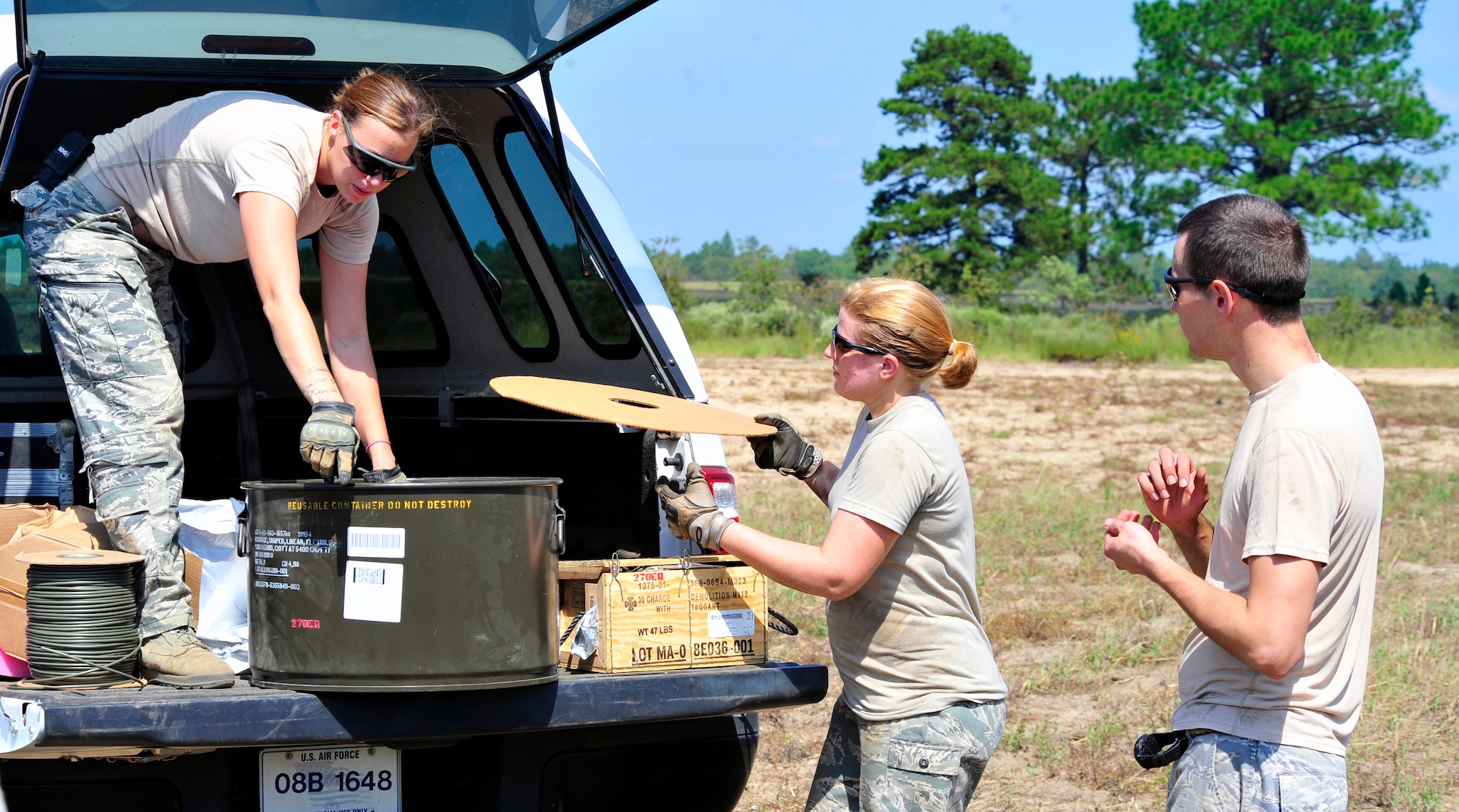 Senior Airman Kristi Stubbs, Tech. Sgt. Kim Mahan and Senior Airman Richard Mirabal, 20th Civil Engineer Squadron explosive ordnance disposal technicians, unload a container of explosives from a truck at Poinsett Range near Wedgefield, S.C., Sept. 23, 2010. EOD techs are called upon when unexploded bombs need to be dealt with. (U.S. Air Force photo by Senior Airman Daniel Phelps/Released)