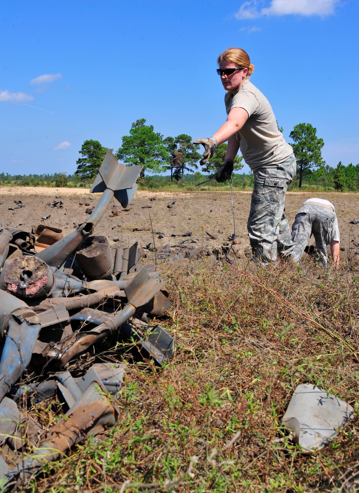Tech. Sgt. Kim Mahan, 20th Civil Engineer Squadron explosive ordnance technician, tosses a piece of a detonated bomb into a pile at Poinsett Range near Wedgefield, S.C., Sept. 23, 2010. EOD techs are called upon when unexploded bombs need to be dealt with. (U.S. Air Force photo by Senior Airman Daniel Phelps/Released)