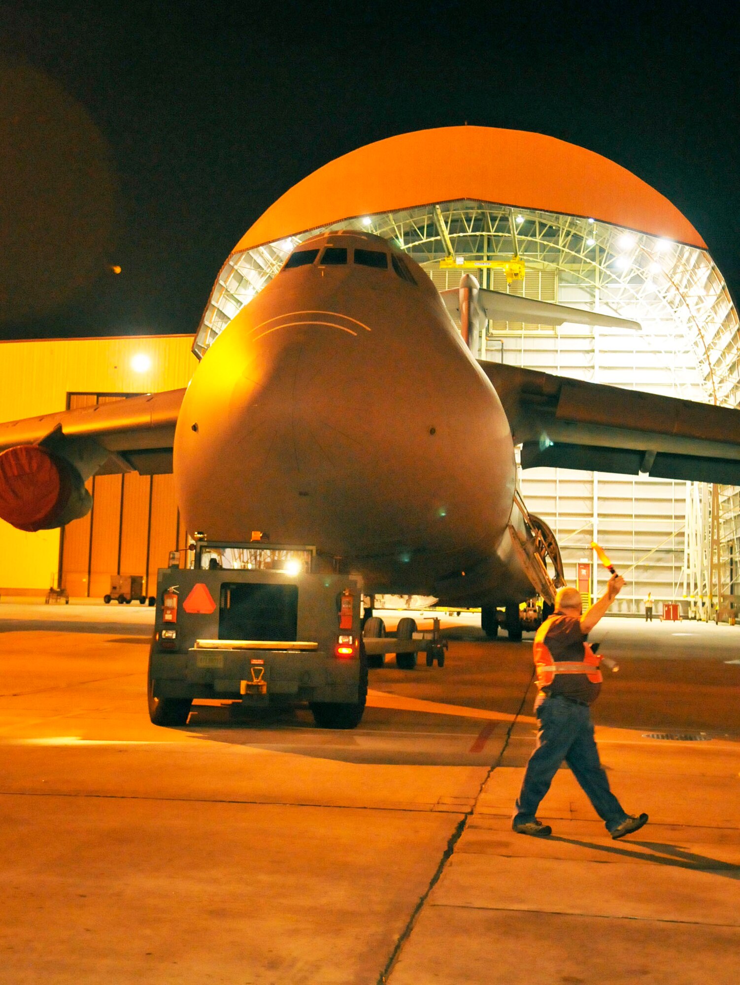 Bobby Hubbard, tow chief, marshalls a C-5 as it is moved out of a hangar to a spot on the Robins flightline. The aircraft from Travis Air Force Base was here for a horizontal stabilizer replacement. (U. S. Air Force photo by Sue Sapp)