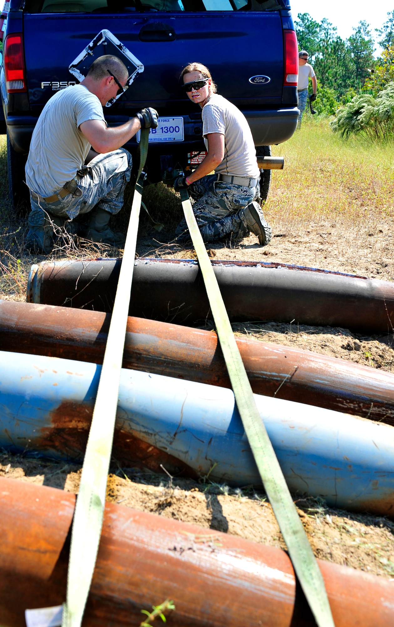 Senior Airmen Kameron Griffin and Kristi Stubbs, 20th Civil Engineer Squadron explosive ordnance disposal technicians, attach ropes to unexploded bombs to line them up for detonation at Poinsett Range near Wedgefield, S.C., Sept. 23, 2010. EOD techs are called upon when unexploded bombs need to be dealt with. (U.S. Air Force photo by Senior Airman Daniel Phelps/Released)