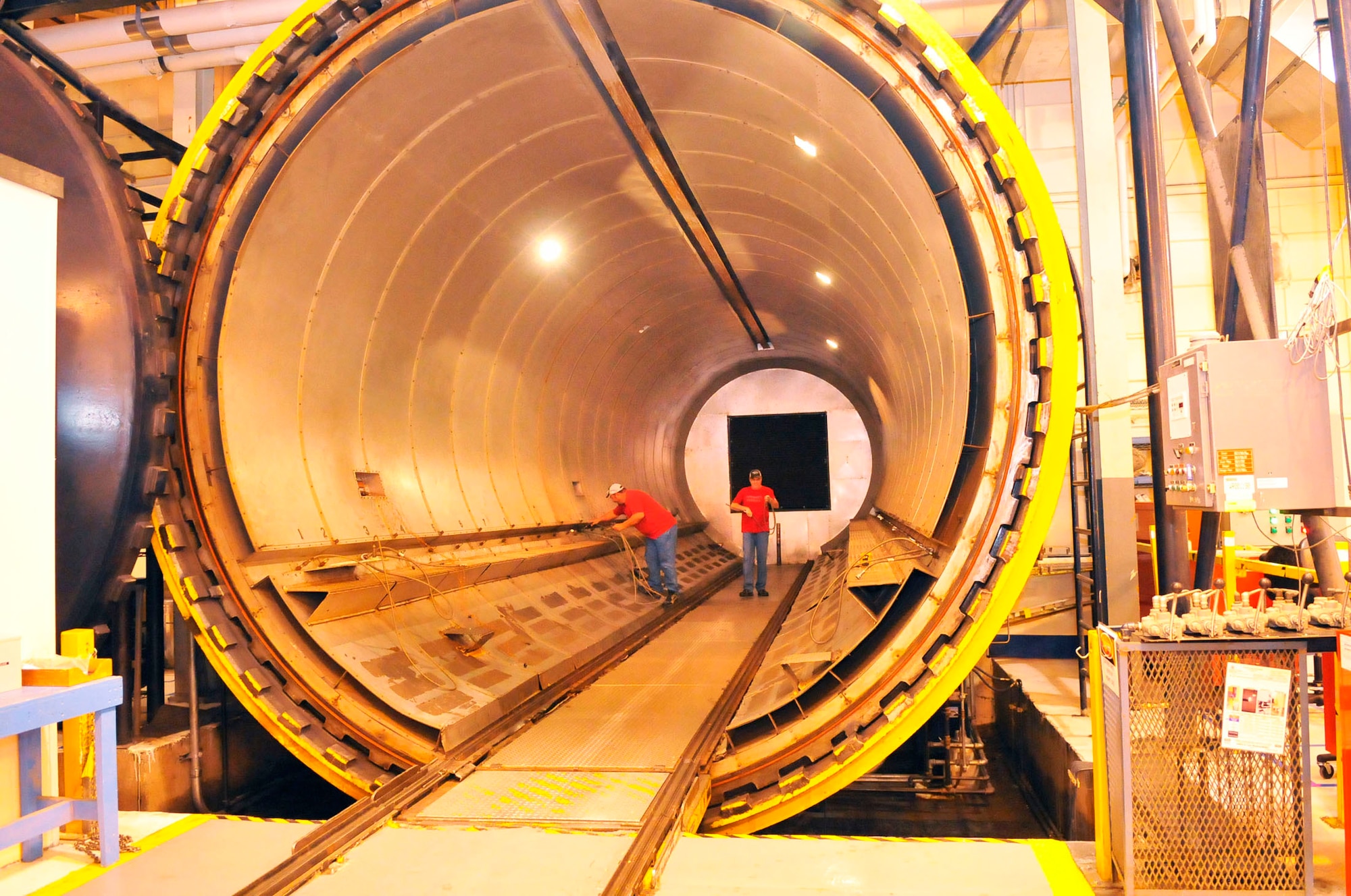 Johnny Moncrief and William Lowery, 574th Sructural Repair Squadron, clear out the autoclave during the owl shift in Bldg. 169. Autoclaves are pressure vessels used to process parts and materials which require exposure to elevated pressure and temperature. (U. S. Air Force photo by Sue Sapp)