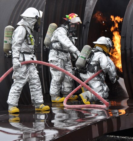 Staff Sgt. Kyle Scritchfield (center), 9th Civil Engineer Squadron fire protection crew chief, guides other Beale firemen at an aircraft interior fire on a simulated aircraft at Beale Air Force Base, Calif., March 19, 2012. Beale firemen routinely utilize the aircraft simulation pit to train at combating aircraft fires. (U.S. Air Force photo by Staff Sgt. Robert M. Trujillo/Released) 