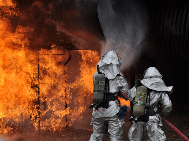 Beale firefighters, Airman 1st Class Sean Russell and Staff Sgt. Nathan Shaw battle an aircraft fire on a simulated aircraft at Beale Air Force Base, Calif., March 19, 2012. Beale firefighters routinely train at the aircraft simulation pit to enhance their skills and showcase their abilities to fire department leadership. (U.S. Air Force photo by Staff Sgt. Robert M. Trujillo/Released)