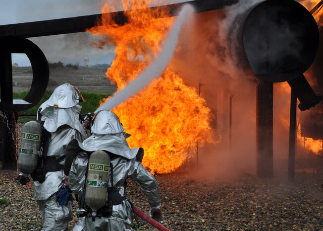 Beale firemen, Airman 1st Class Sean Russell and Staff Sgt. Nathan Shaw, fight an engine fire on a simulated aircraft at Beale Air Force Base, Calif., March 19, 2012. Beale firefighters use a simulated aircraft to train and combat many fire scenarios ranging from engine fires to cockpit fires. (U.S. Air Force photo by Staff Sgt. Robert M. Trujillo/Released) 