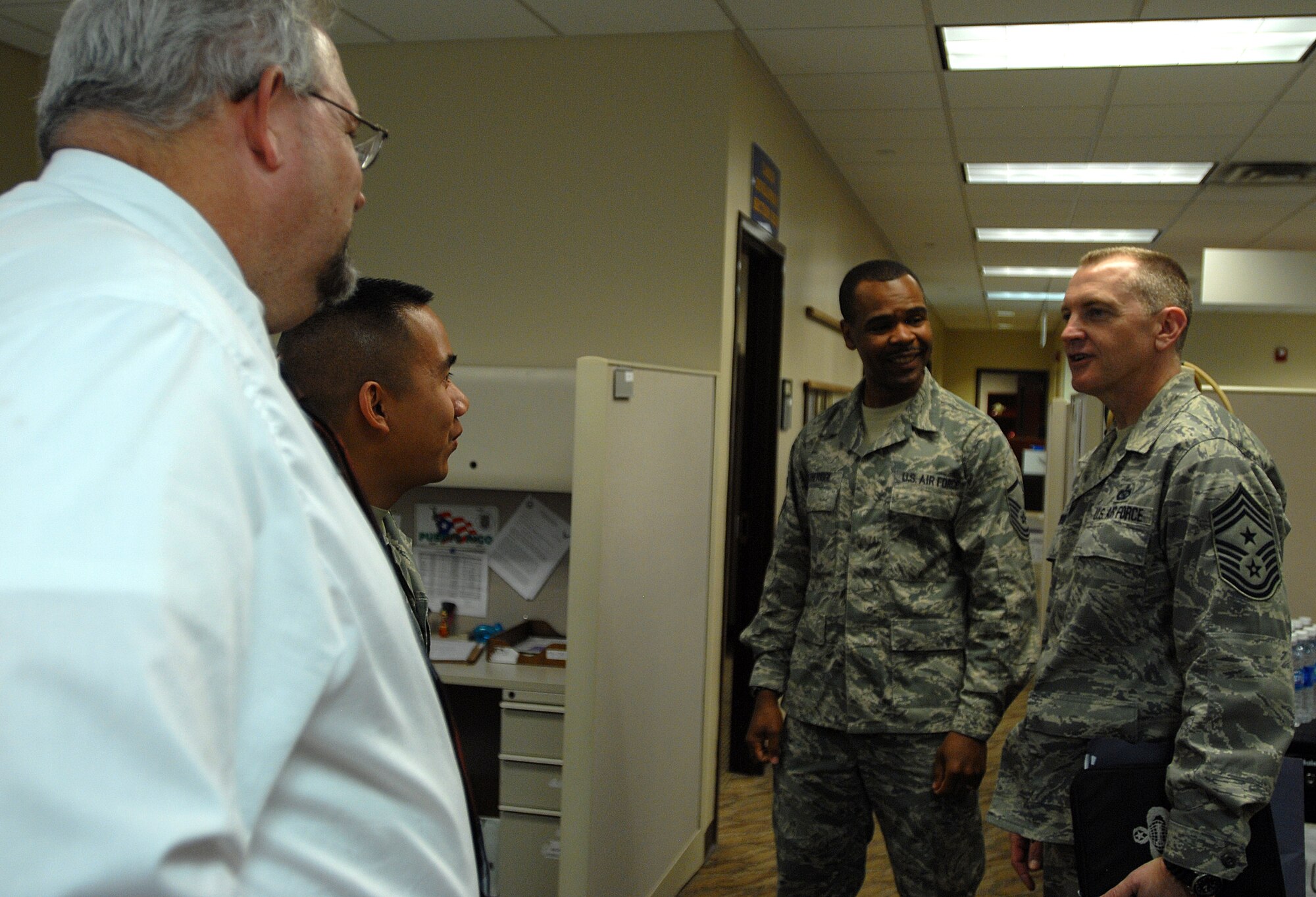 GOODFELLOW AIR FORCE BASE, Texas-- Chief Master Sgt. Scott Lumpkin, 17th Training Wing Command Chief, talks to Master Sgt. Alonzo Etheridge, 2nd Lt. Poonsak Kajonpong and Roger Kuhlmann, 17th Force Support Squadron during a tour of the Military Personnel Flight to March 27. The tour allowed Chief Lumpkin to meet different members of each section in the MPF. (U.S. Air Force photo/ Airman 1st Class Michael Smith)
