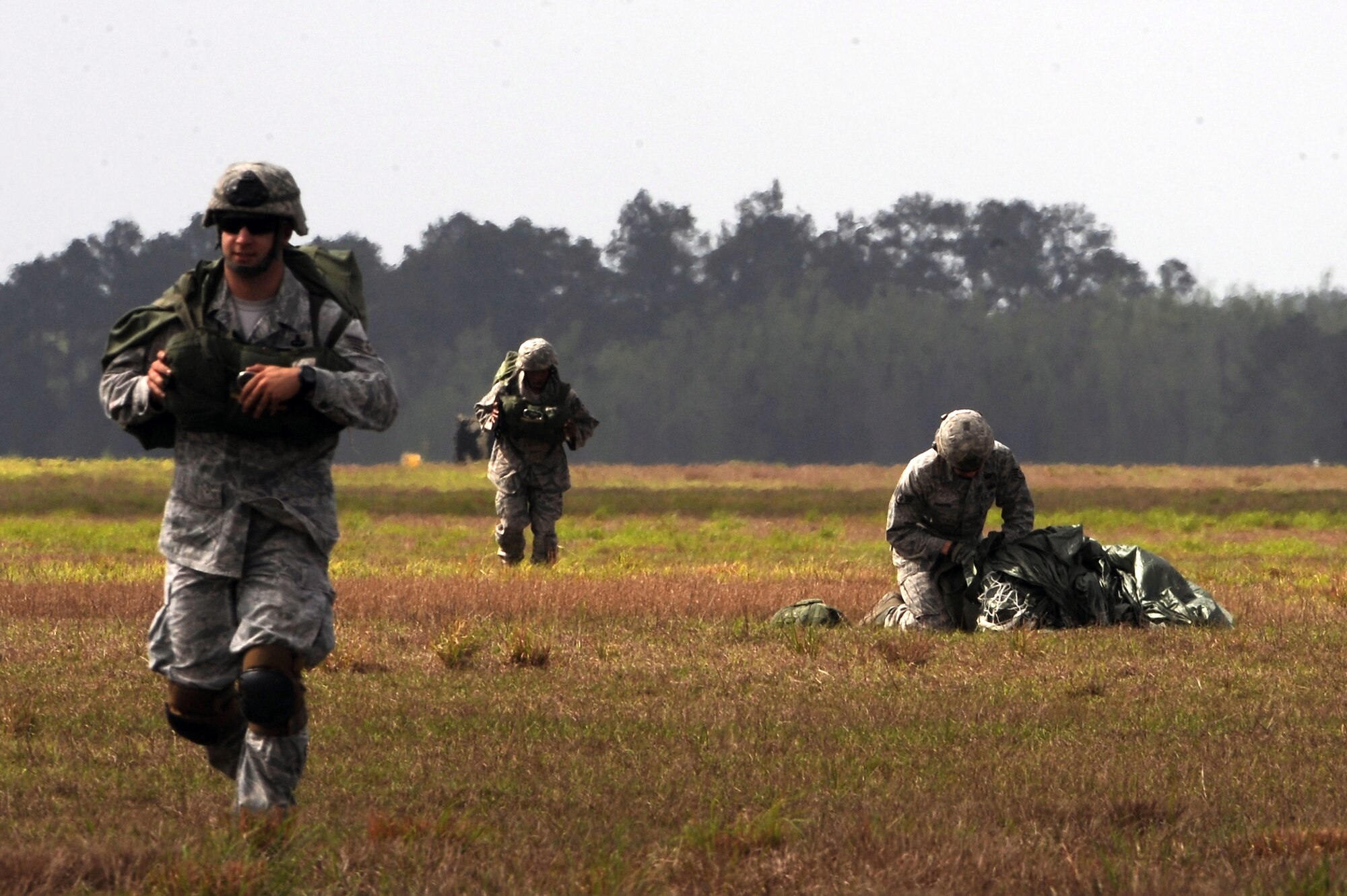 U.S. Air Force Airmen from the 820th Base Defense Group pack up their parachutes and clear a drop zone at Moody Air Force Base, Ga., March 21, 2012.  To become certified, Airmen must complete the U.S.  Army Basic Airborne Course at Fort Benning, Ga. (U.S. Air Force photo by Staff Sgt. Ciara Wymbs/Released)