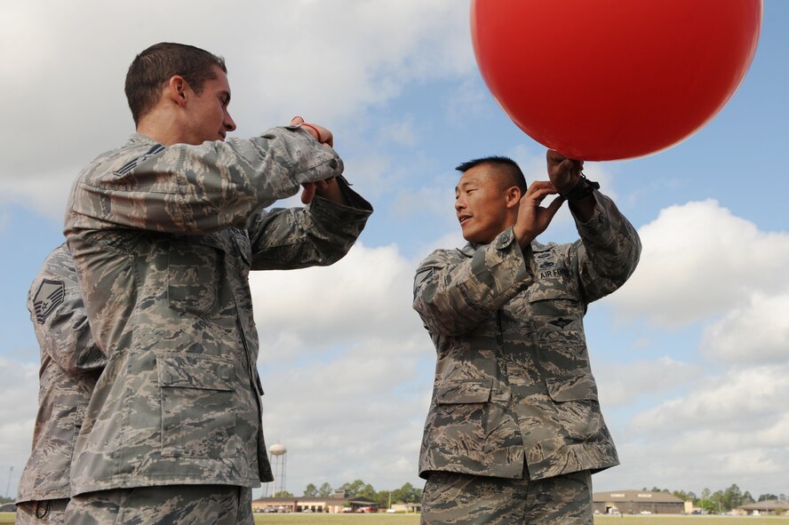 U.S. Air Force Master Sgt. Samuel Louie and Senior Airman Kyle Coughlin, 820th Base Defense Group, prepare to release a pibal at Moody Air Force Base, Ga., March 21, 2012. A pibal or pilot observation balloon is used to measure the speed and direction of winds by recording data throughout various stages of the atmosphere. (U.S. Air Force photo by Staff Sgt. Ciara Wymbs/Released)