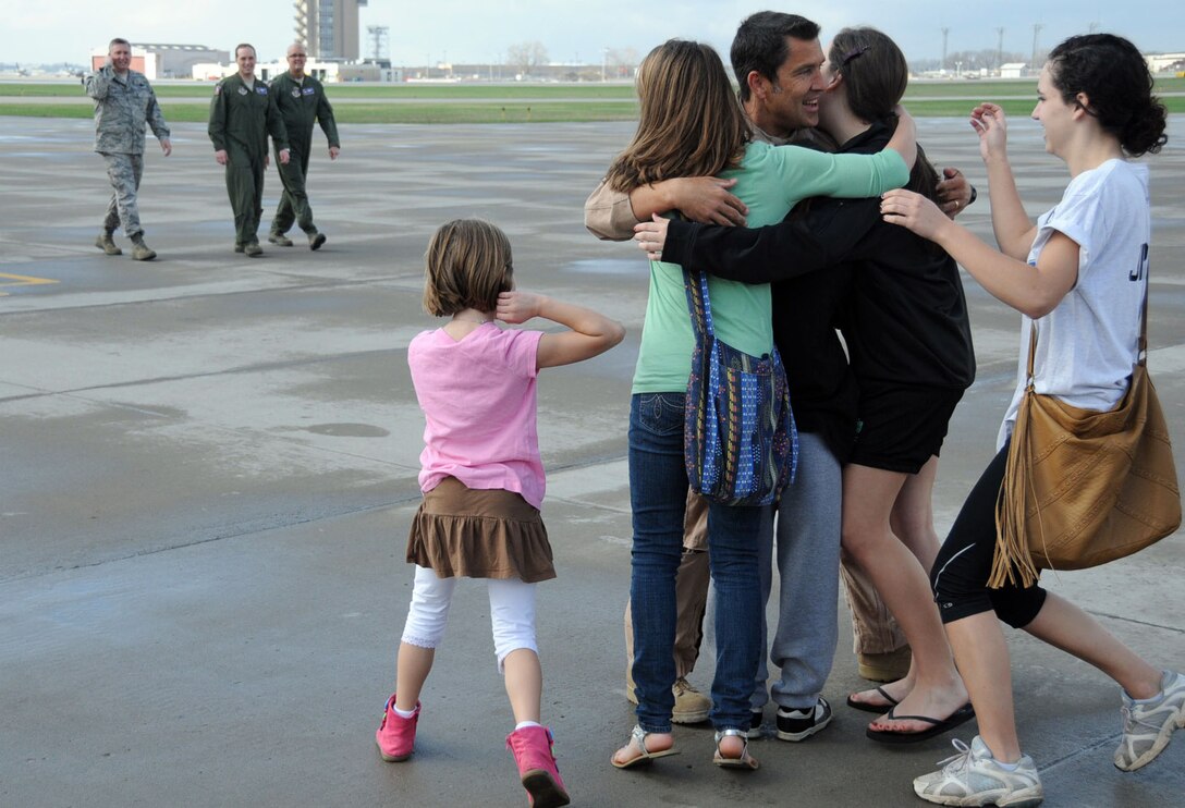 Lt. Col. Jim Jirele, 934th Operations Group, reuinutes with his family March 23 at the 9344th Airlift Wing upon returning from a deployment to Southwest Asia. (Air Force Photo/Paul Zadach) — at 934th Airlift Wing.

