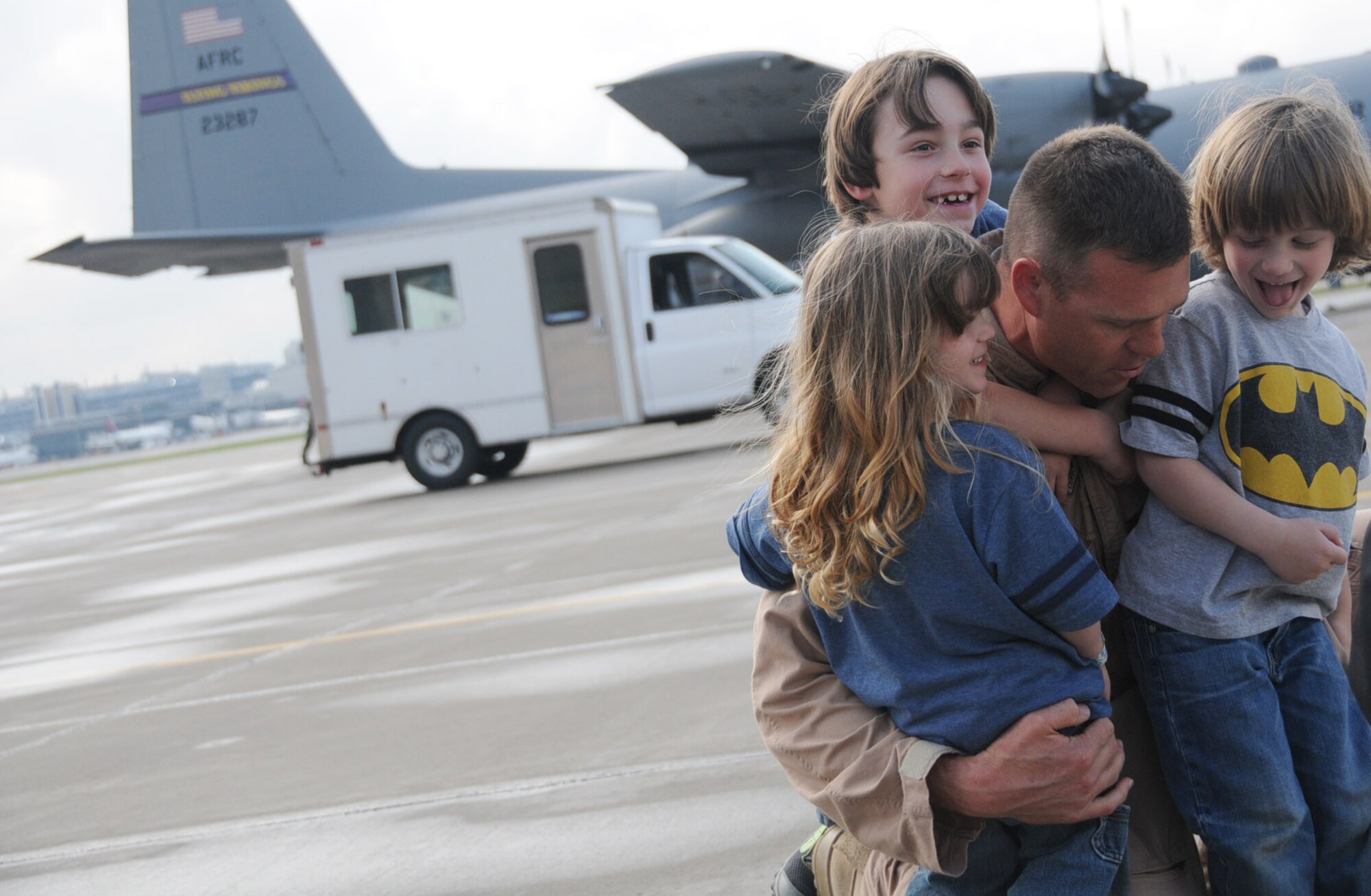 Lt. Col. Marty Schulting, 96th Airlift Squadron, embraces his family at the 934th Airlift Wing March 23 as he returns from a deployment to Southwest Asia. (Air Force Photo/Paul Zadach) — at 934th Airlift Wing.
