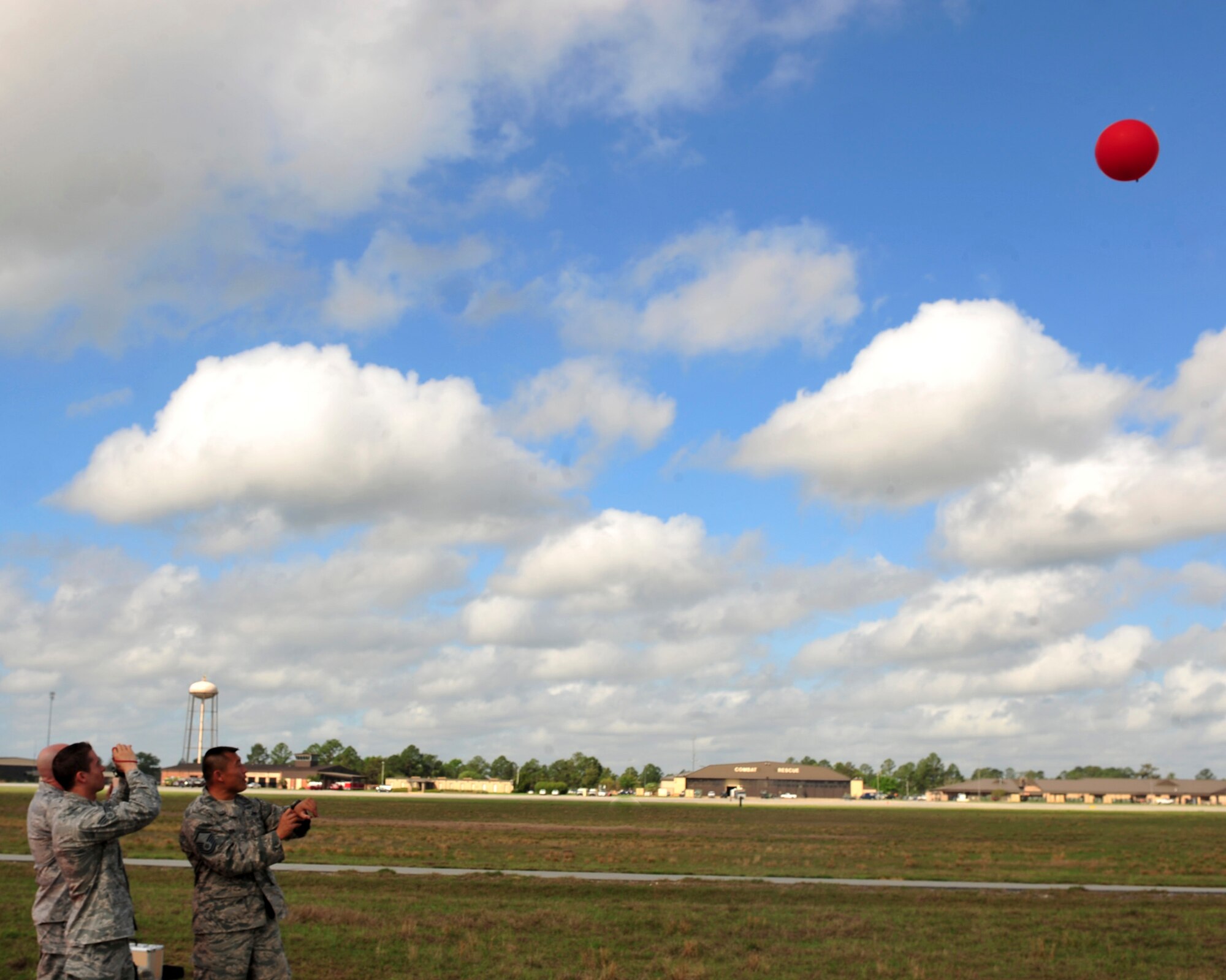 U.S. Air Force Senior Airman Kyle Coughlin, Master Sgt. David Brown and Master Sgt. Samuel Louie, 820th Base Defense Group, monitor a pibal balloon to ensure the sky is clear for 1,500 feet above the drop zone at Moody Air Force Base, Ga., March 21, 2012.  To ensure safety, the unit checks visibility and wind speed prior to each parachute training jump.(U.S. Air force photos by Staff Sgt. Stephanie Mancha/Released)
