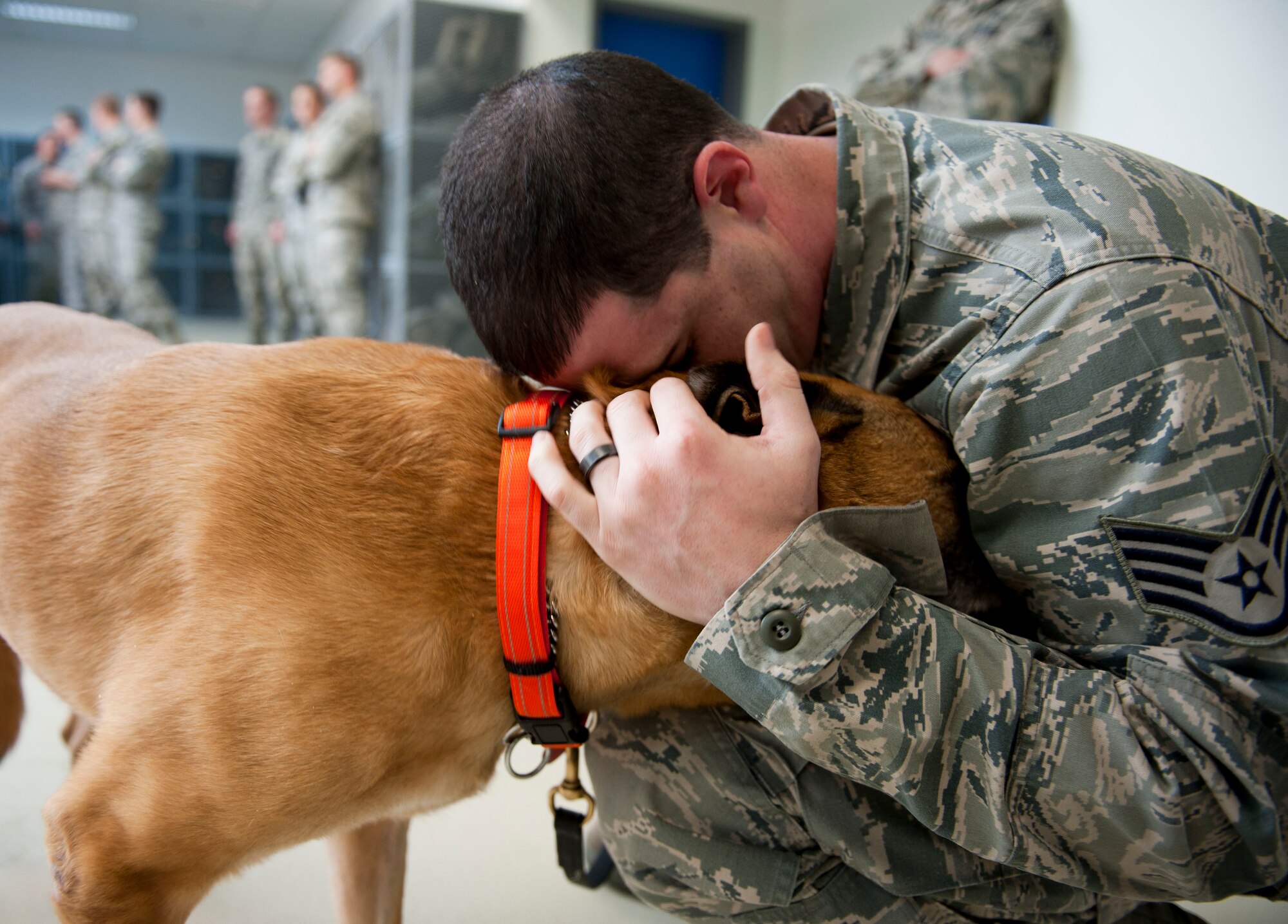 Staff Sgt. Joshua Ball, 39th Maintenance Squadron, hugs Max, a retired military working dog, prior to the dog's retirement ceremony March 23, 2012 in the 39th Security Forces Squadron guardmount room at Incirlik Air Base, Turkey. Max retired because of deteriorating health conditions caused by age. Max moved in with his adopted owners, the Ball family, a few weeks ago while the squadron planned his formal retirement. (U.S. Air Force photo by Senior Airman William A. O'Brien/Released)