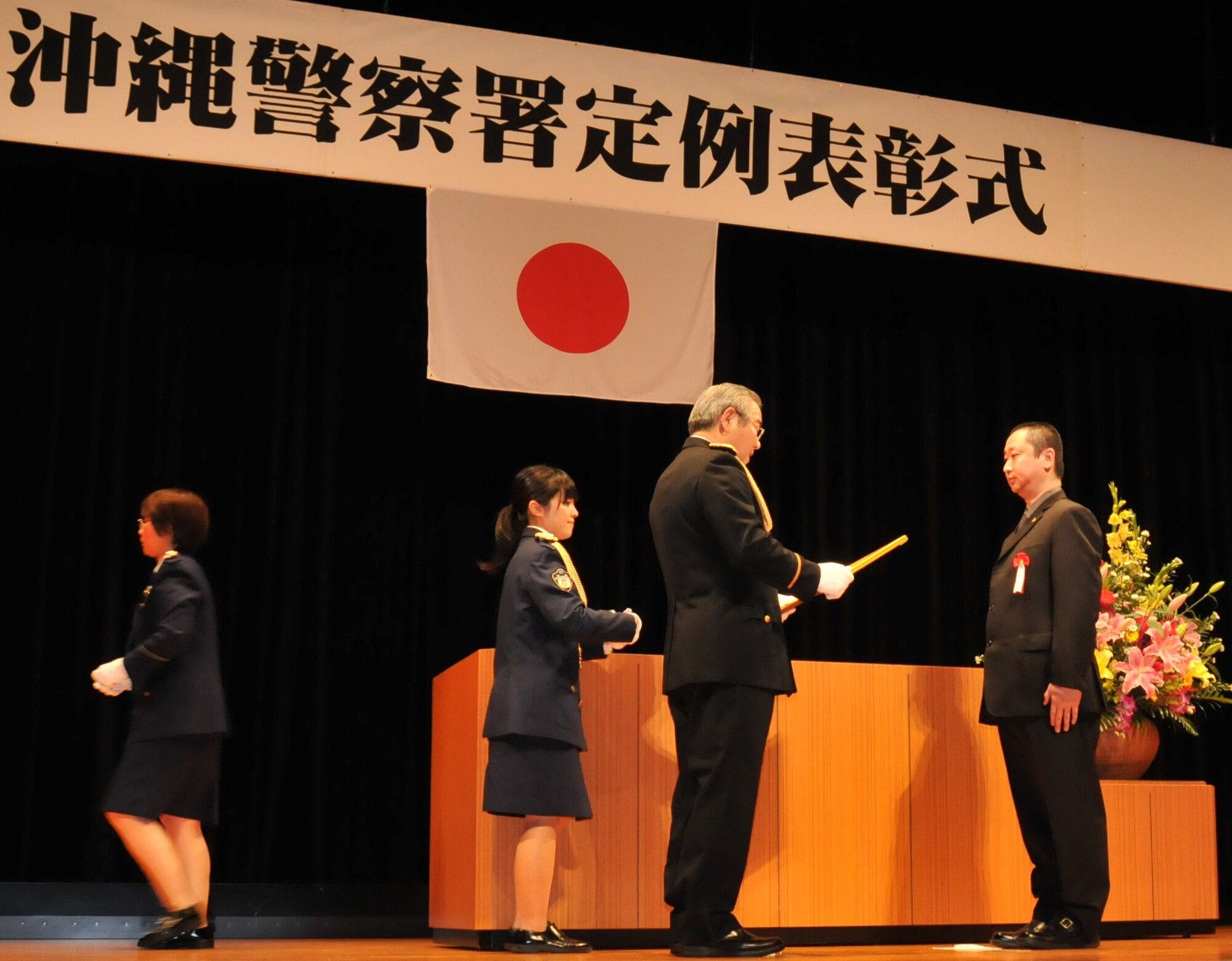 Special Investigator Kazuma Tengan (right), U.S. Air Force Office Special Investigations, receives a letter of appreciation from Kiyomasa Yasumura (center), Chief of the Okinawa Police Station, at the Okinawa Police Station's annual appreciation ceremony in Okinawa City, Japan, February 22, 2012. Tengan received the letter of appreciation for being the liaison between OSI and OPS during 2011. (U.S. Air Force courtesy photo/Released)