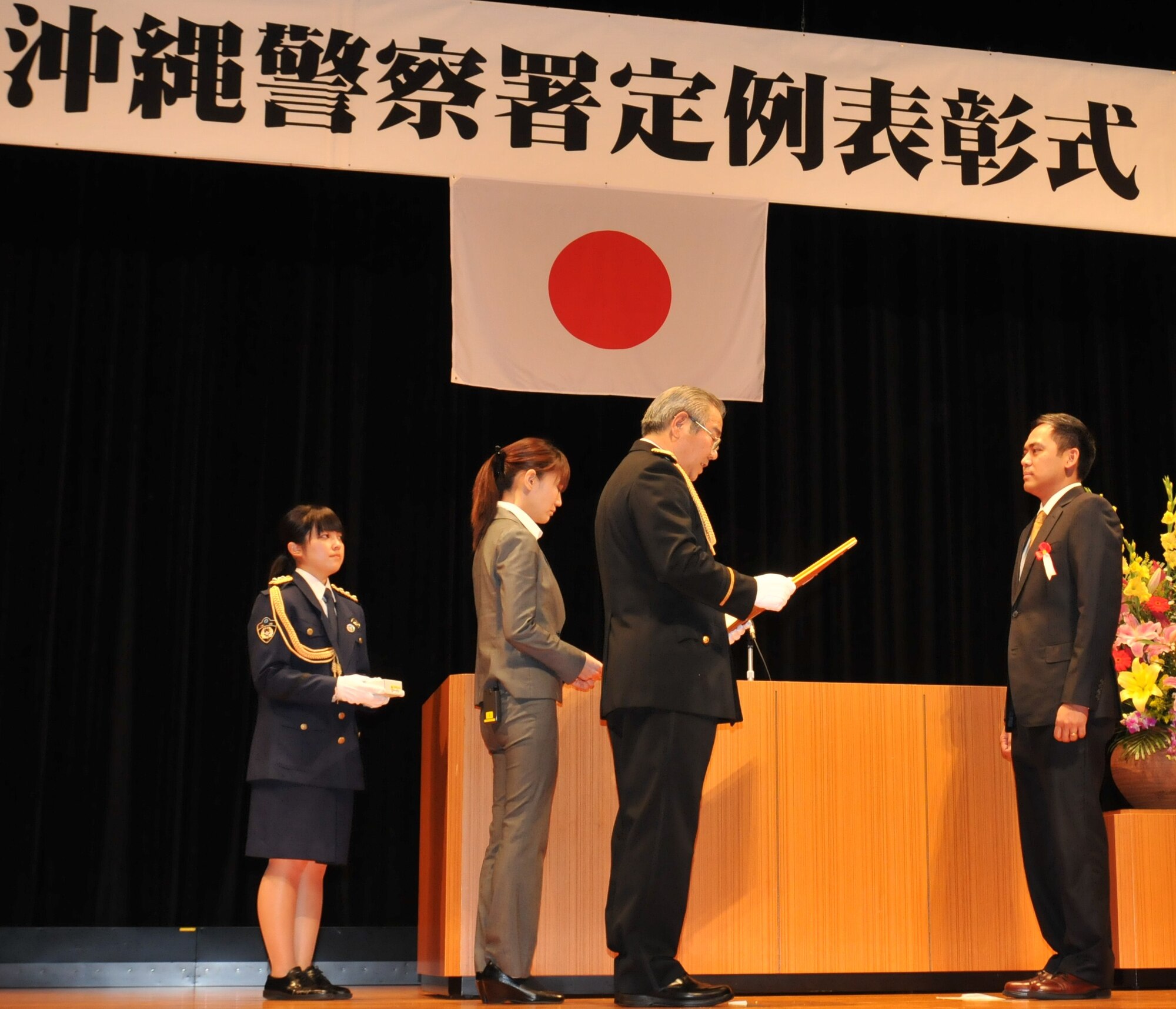 Special Agent Joseph Laville (right), U.S. Air Force Office of Special Investigations Detachment 624, receives a letter of appreciation from Kiyomasa Yasumura (center), Chief of the Okinawa Police Station, at the Okinawa Police Station's annual appreciation ceremony in Okinawa City, Japan, February 22, 2012. The letter of appreciation was for assisting in various police activities on Okinawa during 2011. (U.S. Air Force courtesy photo/Released)