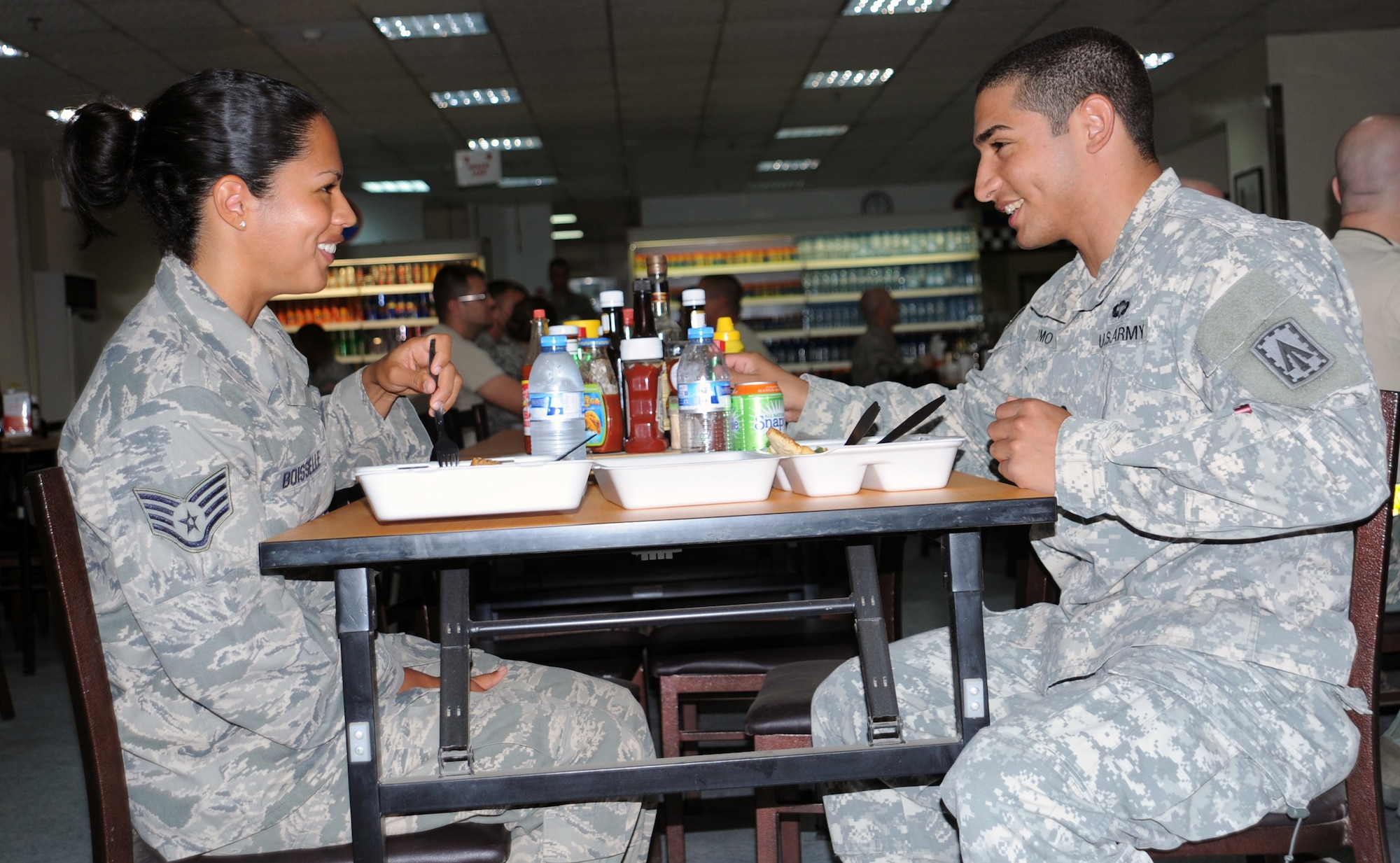SOUTHWEST ASIA - Staff Sgt. Jovan Boisselle and Army Spc. Alberto Romo enjoy lunch together Mar. 24, 2012. The two are siblings deployed together to the 380 Air Expeditionary Wing. She works in supply for E-3 Sentry maintenance and is deployed from Tinker Air Force Base, Okla.; Romo is part of the Patriot missile air defense artillery regiment deployed from Fort Bragg, N.C. (U.S. Air Force photo/Staff Sgt. J.G. Buzanowski)