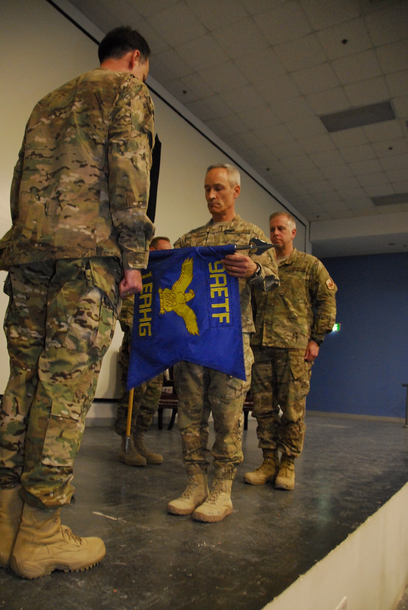 The 1st Expeditionary RED HORSE Group is redesignated the 1st Expeditionary Civil Engineer Group in a ceremony here March 26, 2012. The ceremony included a change of command, from Col. Darren Daniels to Col. John Allen. Maj. Gen. James Jones, U.S. Air Forces Central deputy commander, presided over the event. (U.S. Air Force Photo/Staff Sgt. Nicole Manzanares)