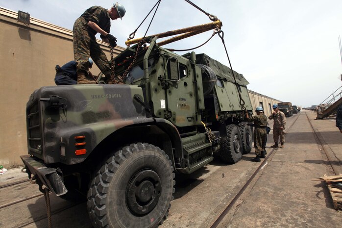 Marines with the 24th Marine Expeditionary Unit and Sailors with the Navy's Iwo Jima Amphibious Ready Group prepare a 7-ton truck to be transported aboard the USS Gunston Hall March 28, 2012. The 24th MEU, partnered with the Iwo Jima Amphibious Ready Group, is deploying to the European and Central Command theaters of operation to serve as a theater reserve and crisis response force capable of a variety of missions from full-scale combat operations to humanitarian assistance and disaster relief. (Official Marine Corps Photo by Sgt. Richard Blumenstein)