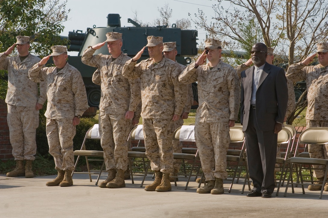 Lieutenant Col. Walker Field (middle), Col. Christian Cabaniss (left from middle) and Sgt. Erik Goodge (right from middle) salute the playing of the national anthem at the beginning of Goodge’s medical retirement ceremony.  Goodge lost his right eye during a deployment to Afghanistan and declined the chance to re-enlist into a non-deployable job and chose to instead medically retire and work to become a police officer in his hometown of Evansville, Ind. (Official U.S. Marine Corps photo by Lance  Cpl. James Frazer)