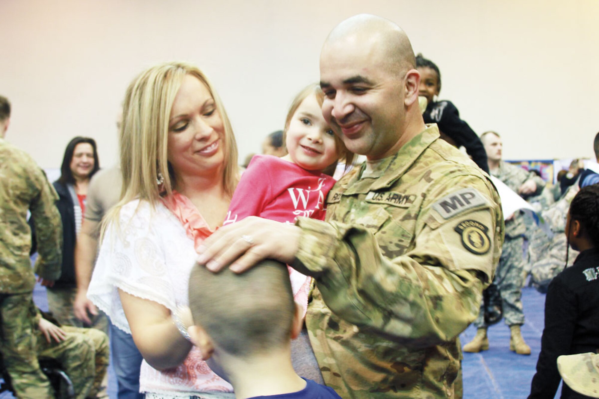 Spc. Danny Rico receives a warm welcome from his wife Katrina and his three children upon returning from his 12 month deployment to Afghanistan Saturday. He, along with his fellow Soldiers of the 164th Military Police Company, 793d Military Police Battalion, mentored and trained Afghan Uniformed Police and Afghan National Army units while providing security for NATO forces in Afghanistan. (U.S. Army photo/Spc. Juana Nesbitt)