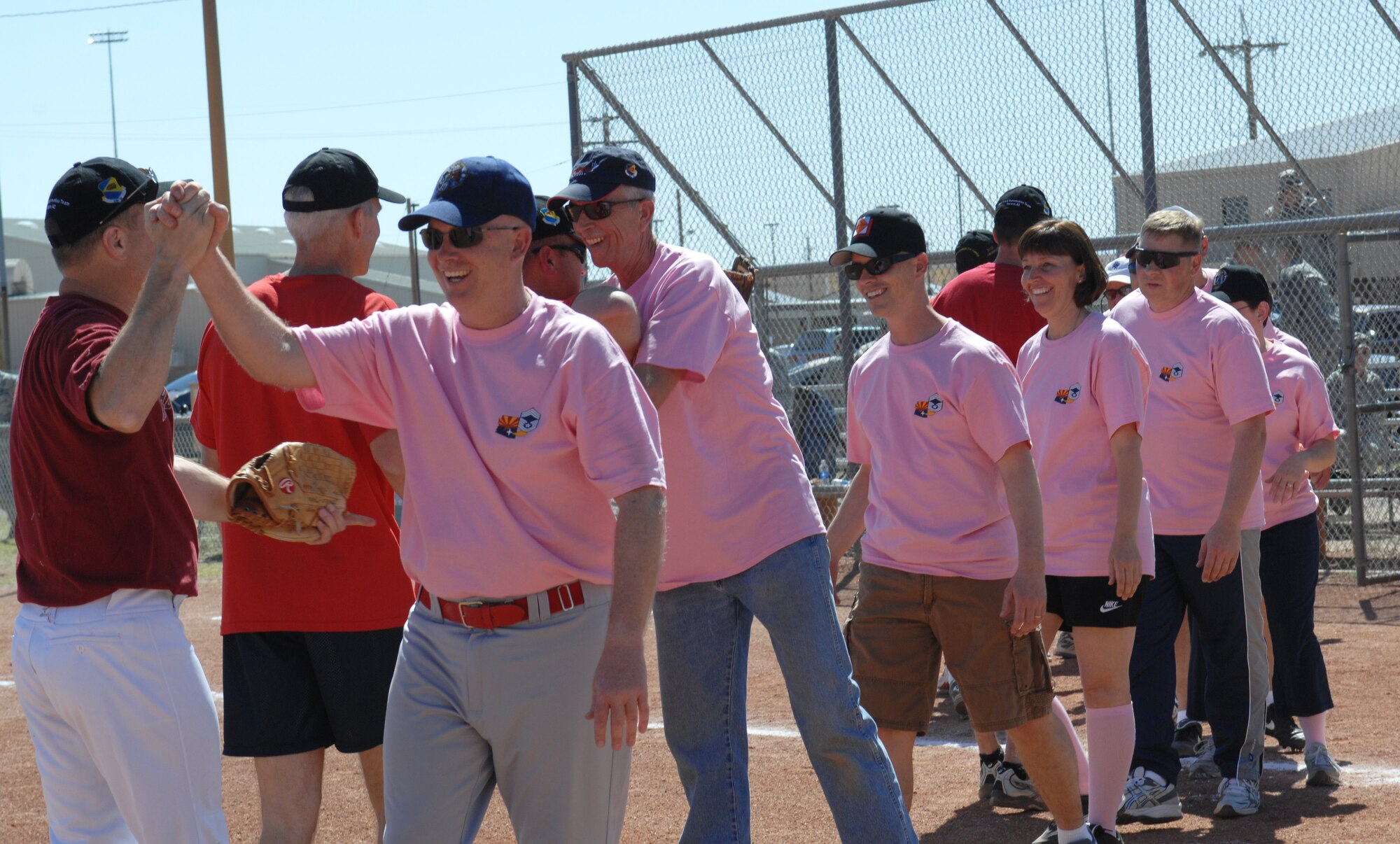 U.S. Air Force participants in the Chiefs vs. Eagles softball game congratulate each other on a game well played at Thunderbolt Field on Davis-Monthan Air Force Base, Ariz., March 23. The annual charity game was won by the Eagles, with a final score of 15-14. (U.S. Air Force photo by Airman 1st Class Saphfire Cook/Released)